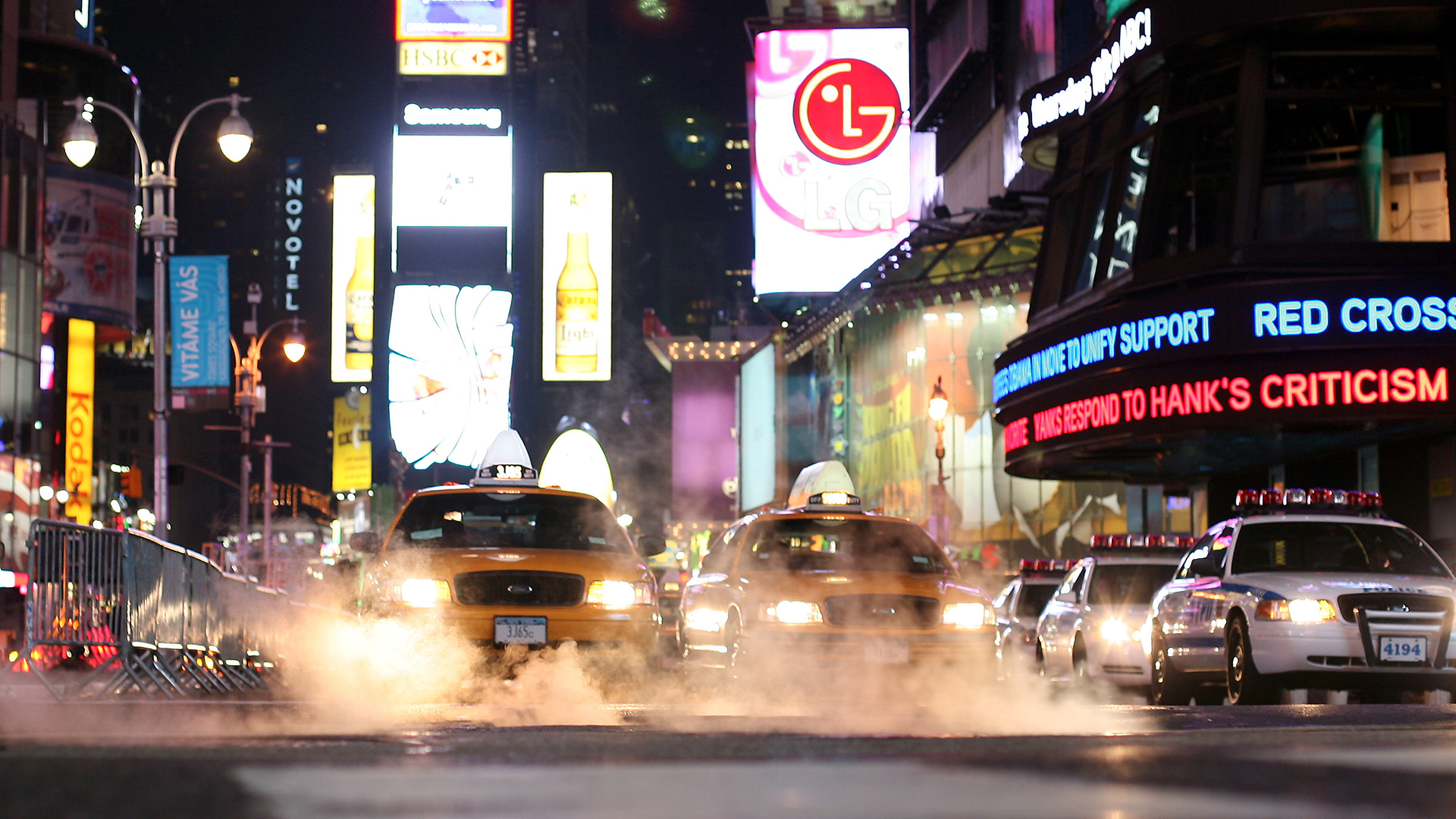 Taxis, so genannte Yellow Cabs, stehen bei Nacht hinter dampfenden Gullies am Times Squares in New York. (Archivbild) | picture-alliance/ dpa