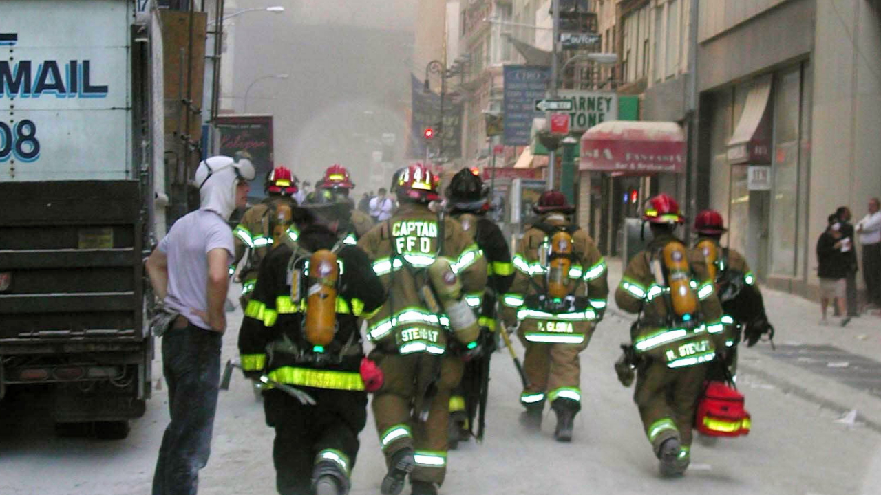 New Yorker Feuerwehrleute am 11.9.2001 auf dem Weg zu den rauchenden Trümmern der World Trade Center | dpa