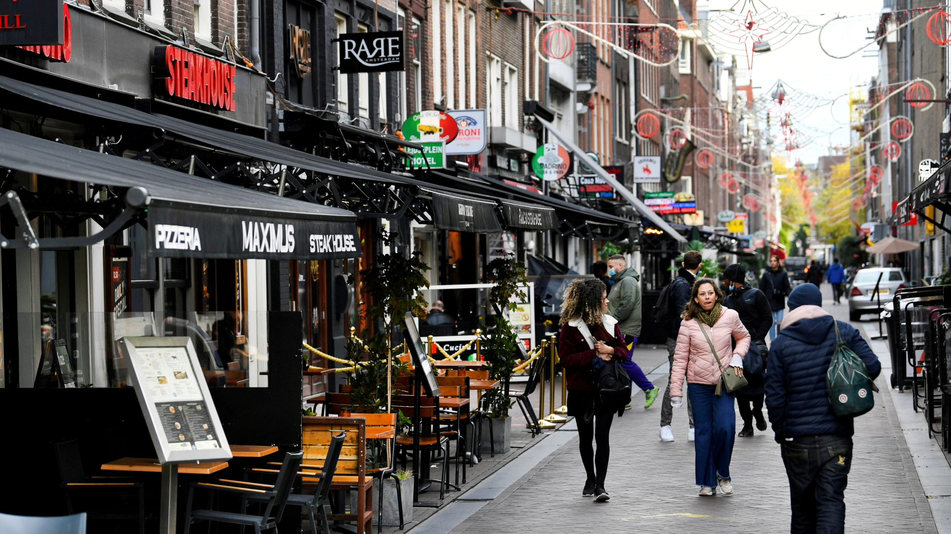 Passanten laufen im Juni 2021 in Amsterdam an Restaurants und Bars vorbei. | REUTERS