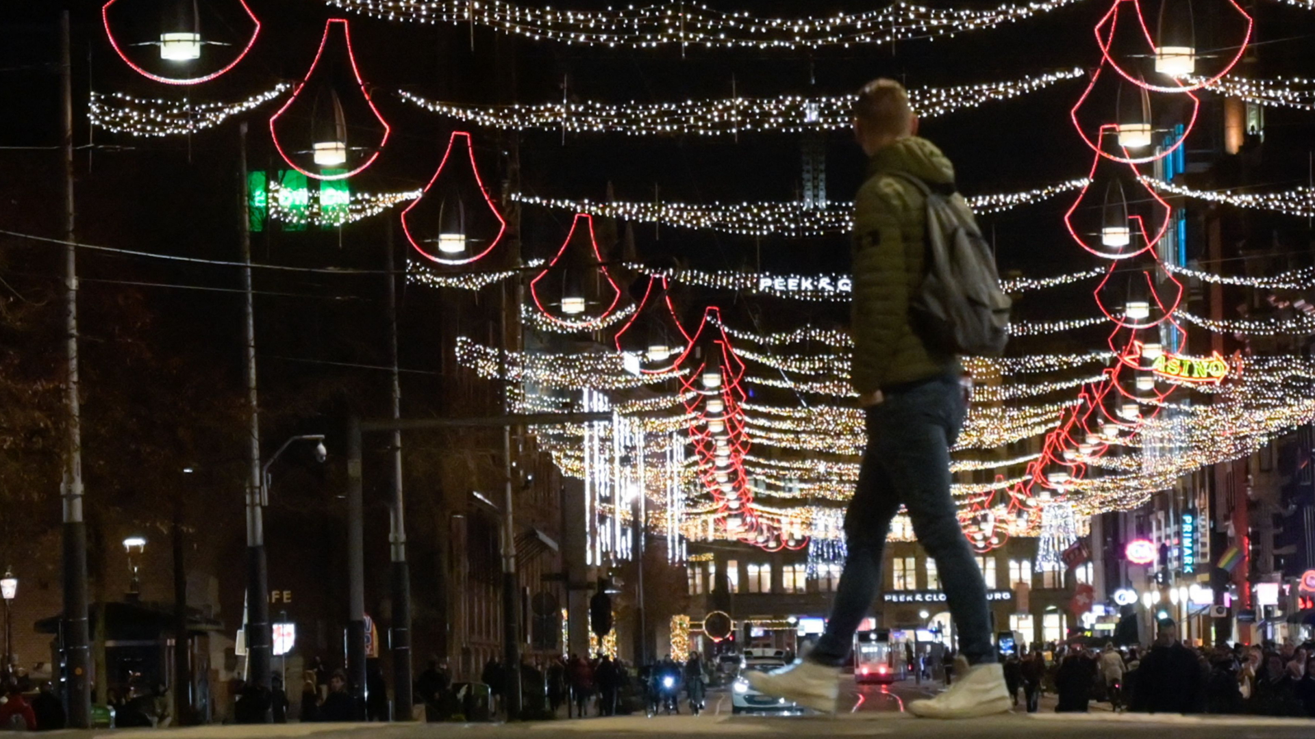 Passanten auf einer mit Weihnachtsbeleuchtung geschmückten Straße in Amsterdam. | AFP