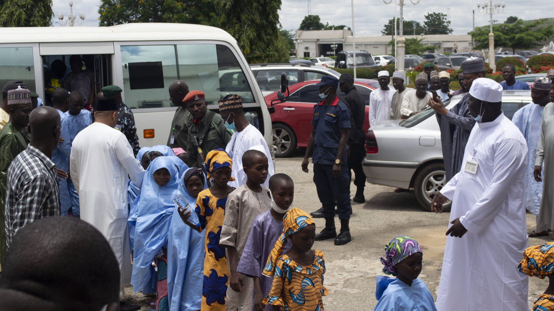 Befreite Kinder verlassen einen Kleinbus. | AP
