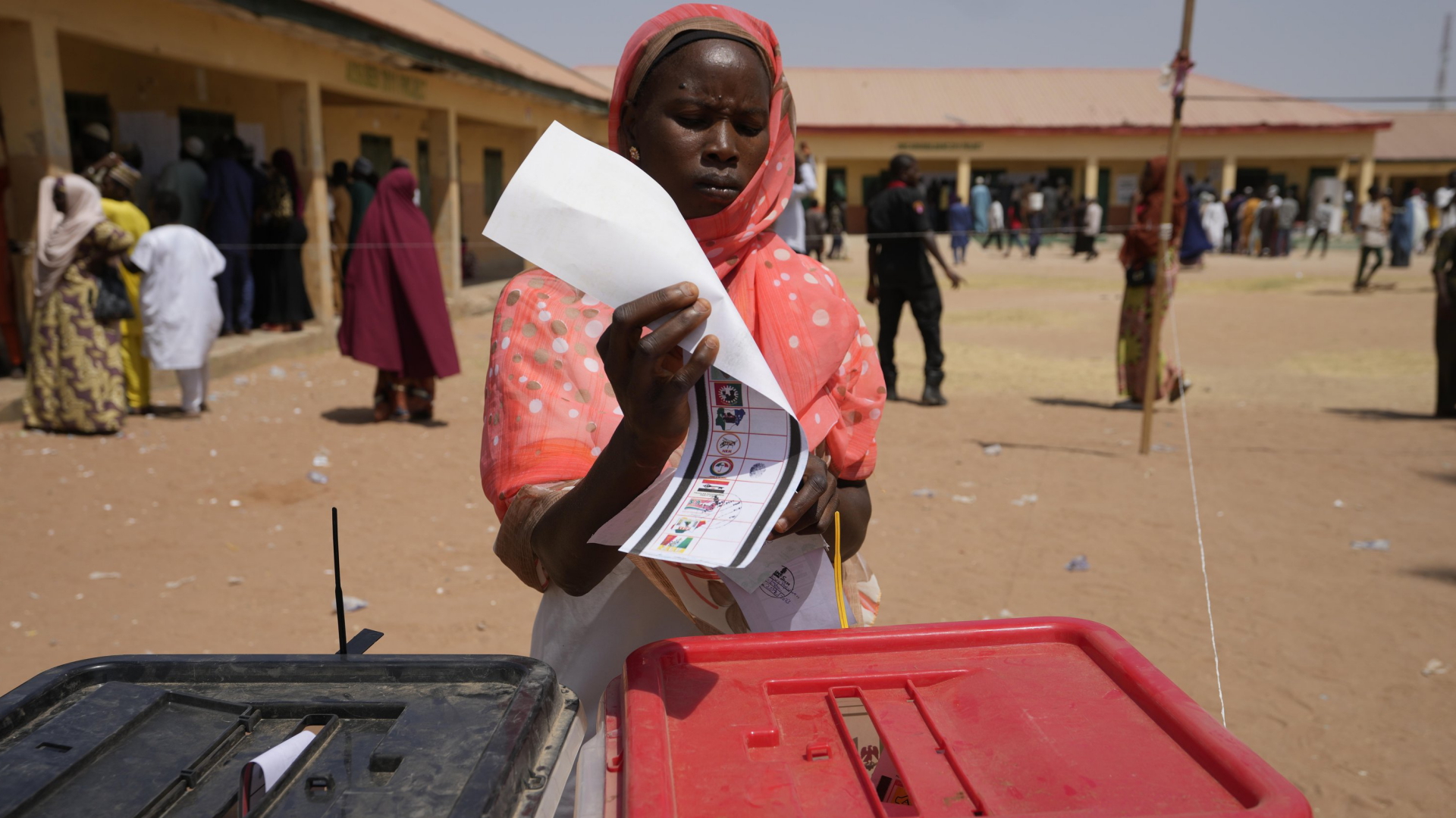 Eine Frau im nigerianischen Yola steckt ihren Wahlzettel in eine Wahlurne. | AP