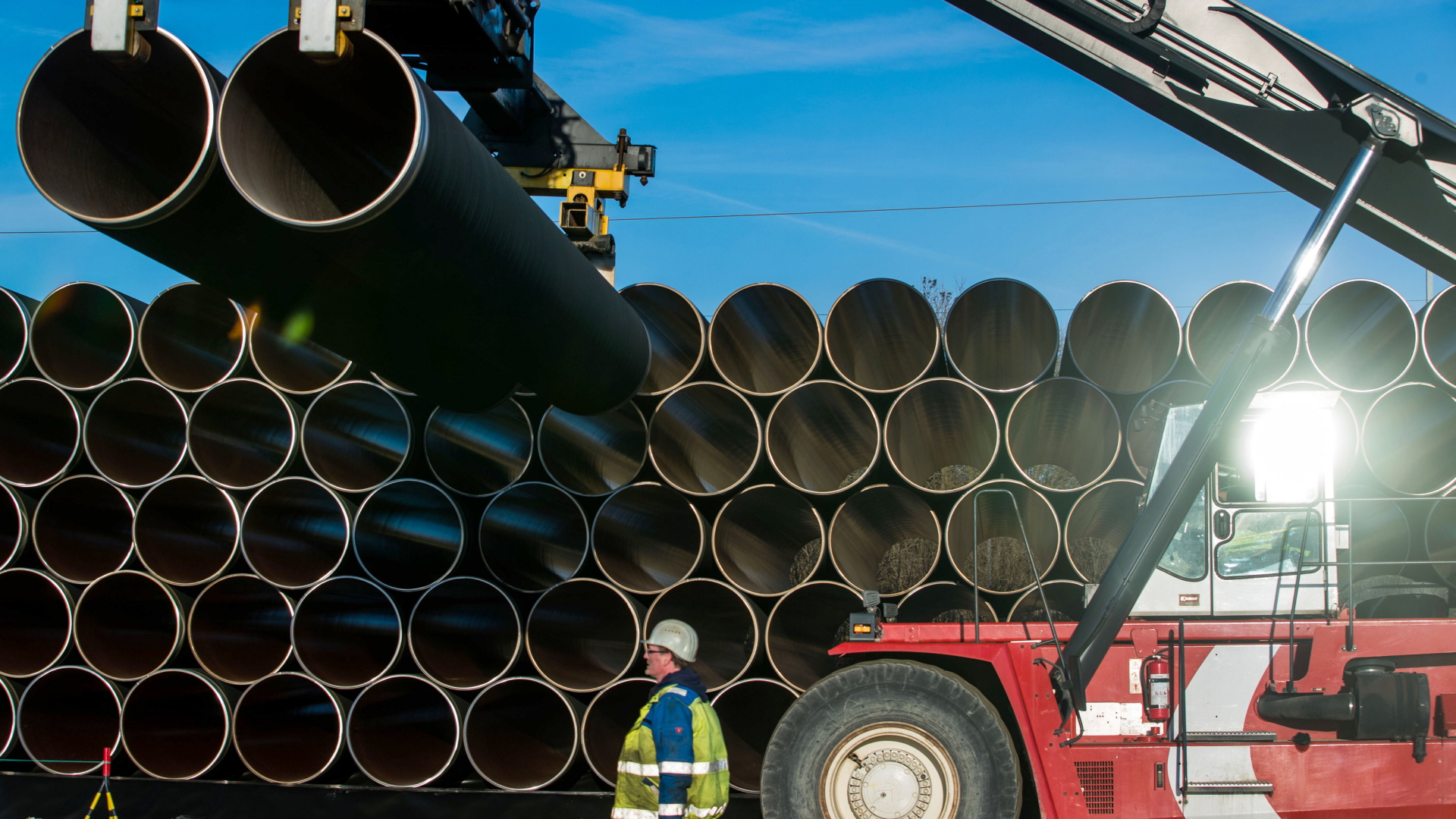 Ein Mitarbeiter überwacht den Transport von Rohren für die geplante Ostseepipeline Nord Stream 2. | dpa
