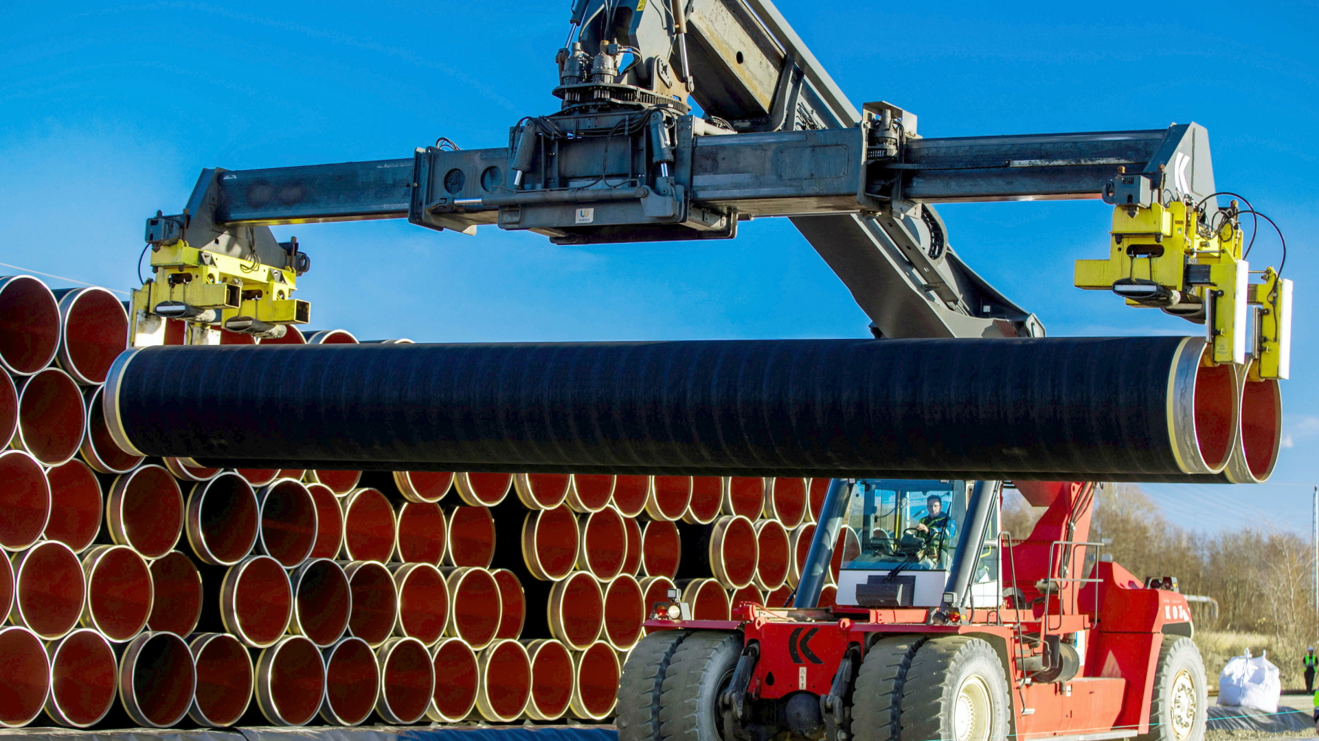 Tonnenschwere Rohre werden für die zukünftige Ostsee-Erdgastrasse Nord Stream 2 im Hafen von Sassnitz-Mukran auf einen Lagerplatz transportiert. | dpa