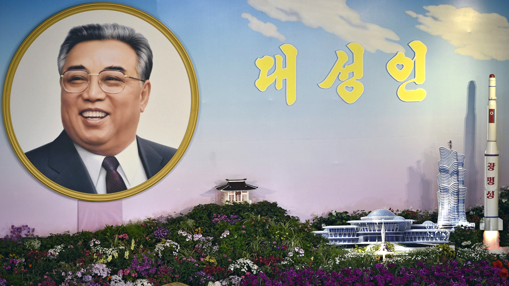 Porträt des nordkoreanischen Staatsgründers Kim Il Sung neben einem Raketenmodell