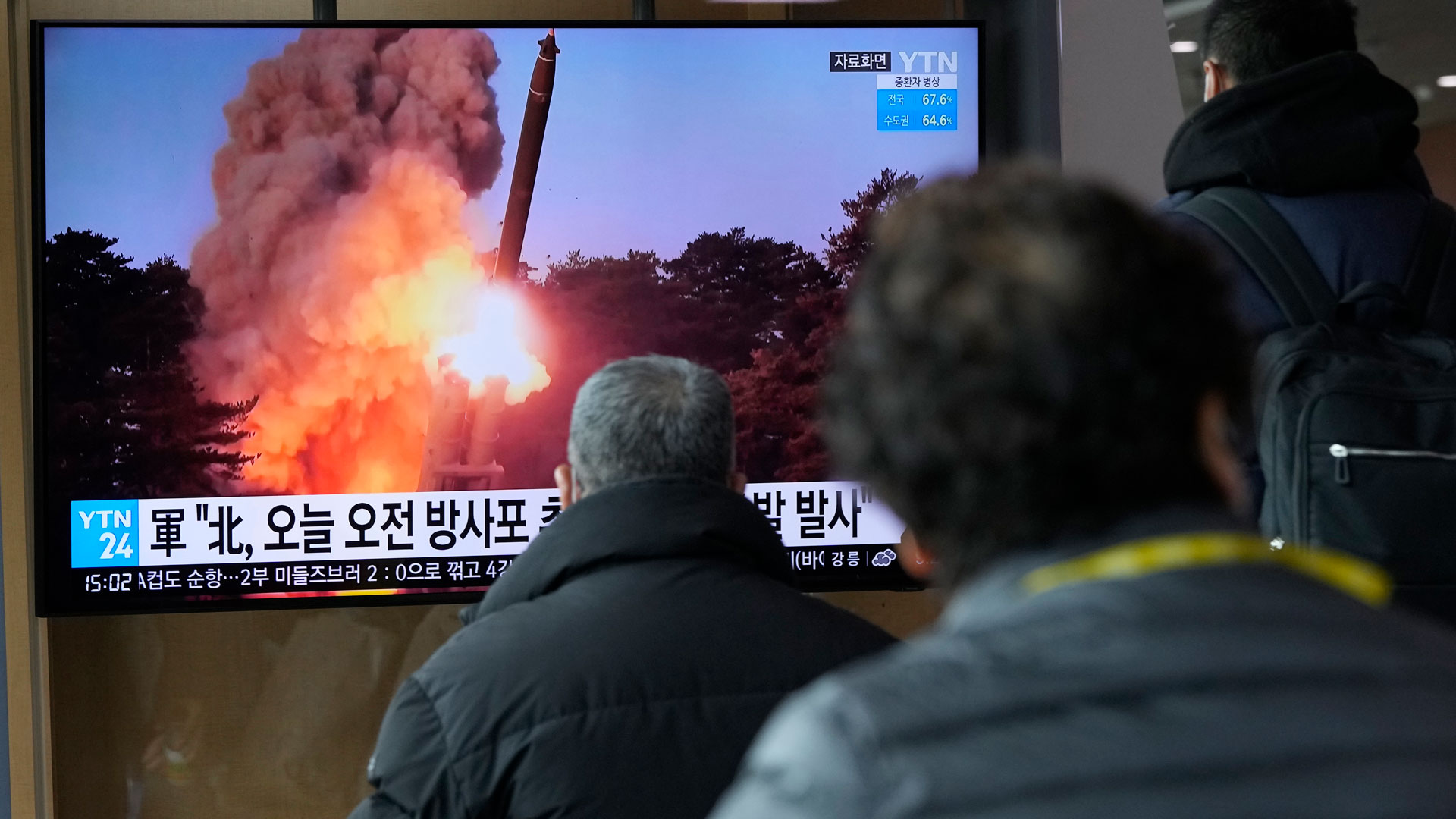 Menschen schauen auf einen Fernsehbildschirm, auf dem eine Nachrichtensendung über den nordkoreanischen Raketenstart gezeigt wird. | dpa