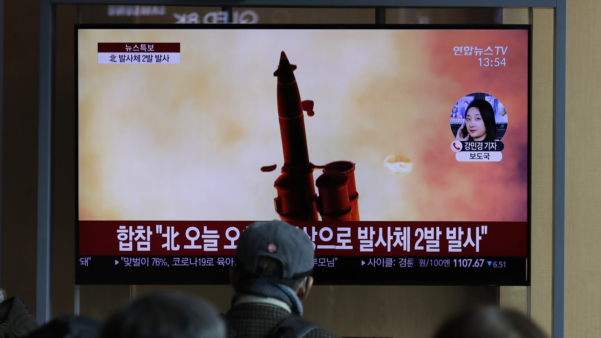 Menschen verfolgen eine Nachrichtensendung über Waffentests von Nordkorea. Auf dem Bildschirm ist eine Rakete zu sehen. | dpa