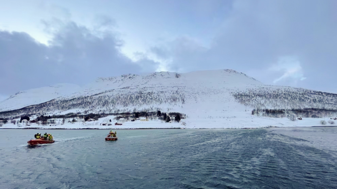 Rettungshelfer sind nach einer Schneelawine auf der Insel Reinöya mit Booten im Einsatz.  | dpa