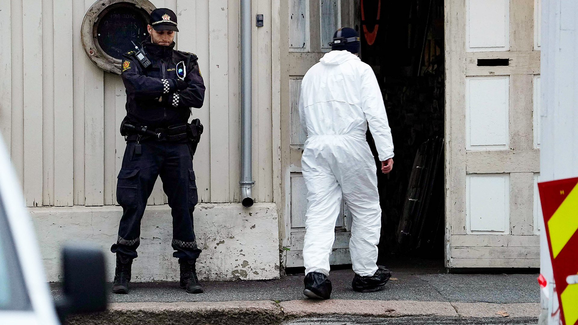 Techniker der Polizei geht nach der Gewalttat in Norwegen in ein Gebäude, vor dem ein Polizist Wache steht. | AFP