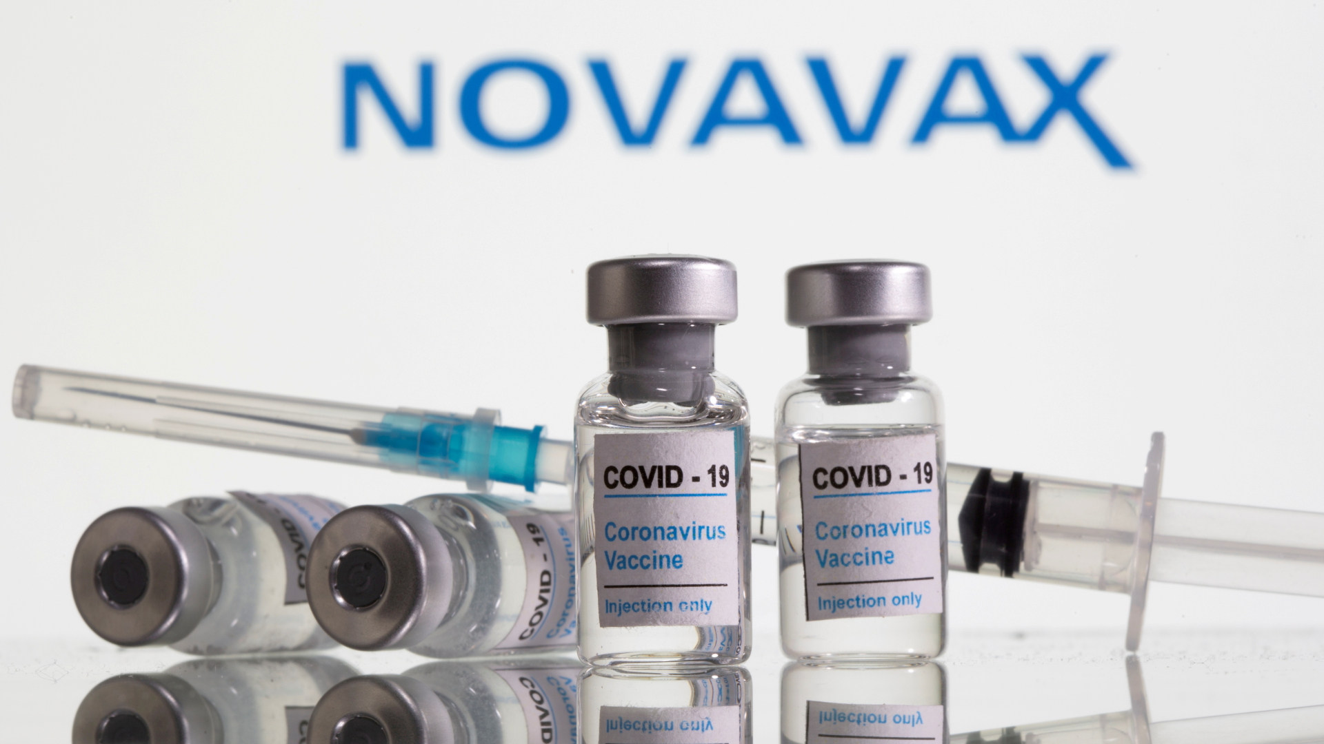 Ampullen des Corona-Impfstoffs von Novavax vor dem Schriftzug des Unternehmens. | REUTERS