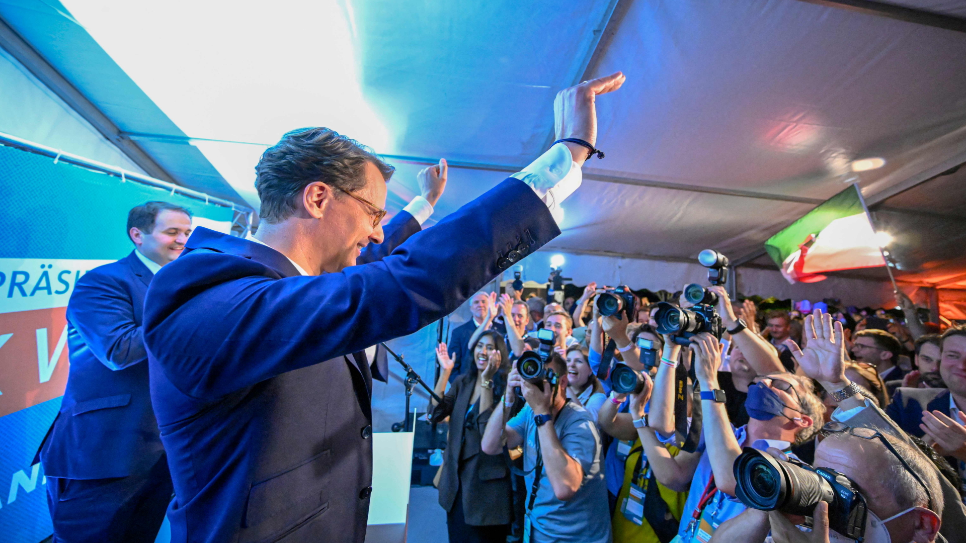 CDU-Ministerpräsident Hendrik Wüst hebt anhand des Wahlsieges seiner Partei in NRW vor einer Menge aus Fotografen und Parteimitgliedern jubelnd die Arme in die Höhe.