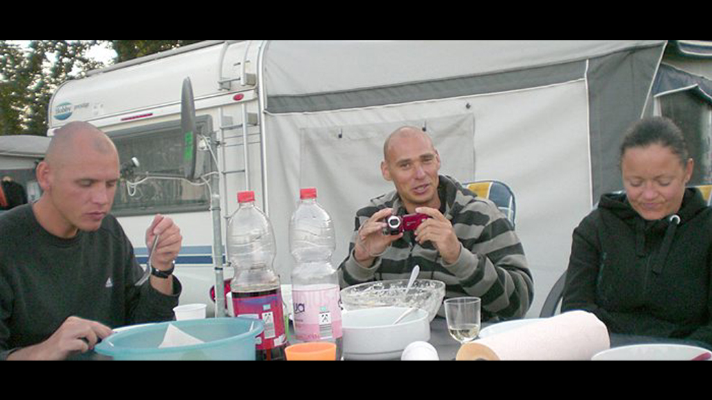 Beate Zschäpe, Uwe Bönhardt und Uwe Mundlos sitzen vor einem Wohnwagen an einem Campingtisch. | dapd