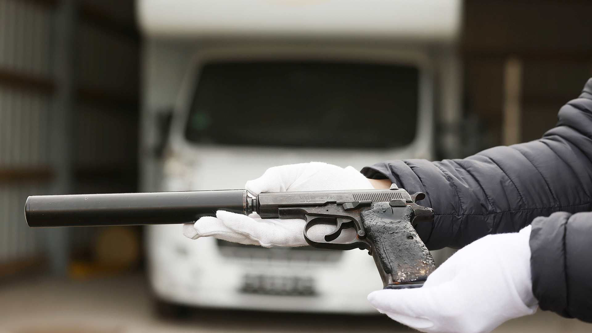  Ein Mitarbeiter des Bundeskriminalamtes hält eine der Tatwaffen, vor dem Wohnmobil der NSU-Terrorzelle in der Hand.  | dpa