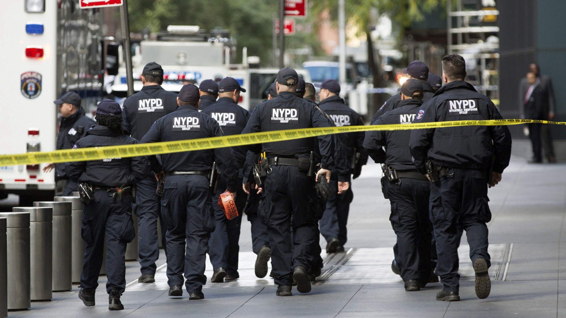 Beamte des NYPD laufen uniformiert vor dem Time Warner Center in Manhatten entlang. | Bildquelle: AP