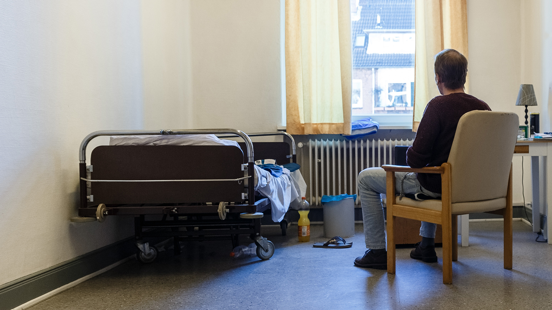 Ein Mann sitzt in der Übernachtungsstätte Pik As in seinem Zimmer. | picture alliance / Markus Scholz