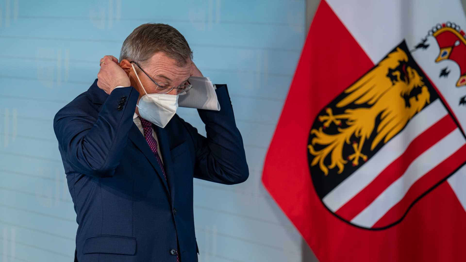 Thomas Stelzer (ÖVP), Landeshauptmann von Oberösterreich, setzt seine Maske im Rahmen einer Pressekonferenz zum Thema "G·impft gewinnt - Oberösterreich startet Impflotterie" auf (Archivbild). | dpa