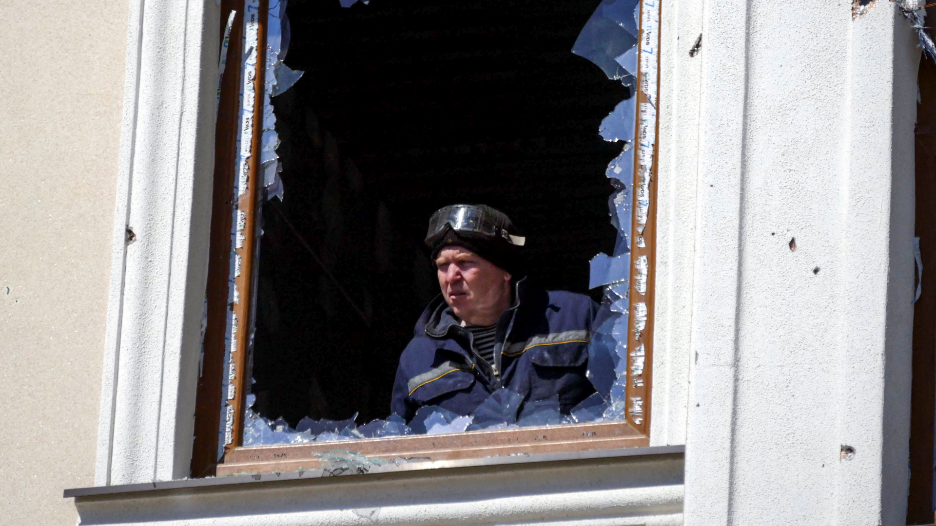 Ein Mann blickt durch das zerstörte Fenster in einem Wohnhaus in Odessa | REUTERS