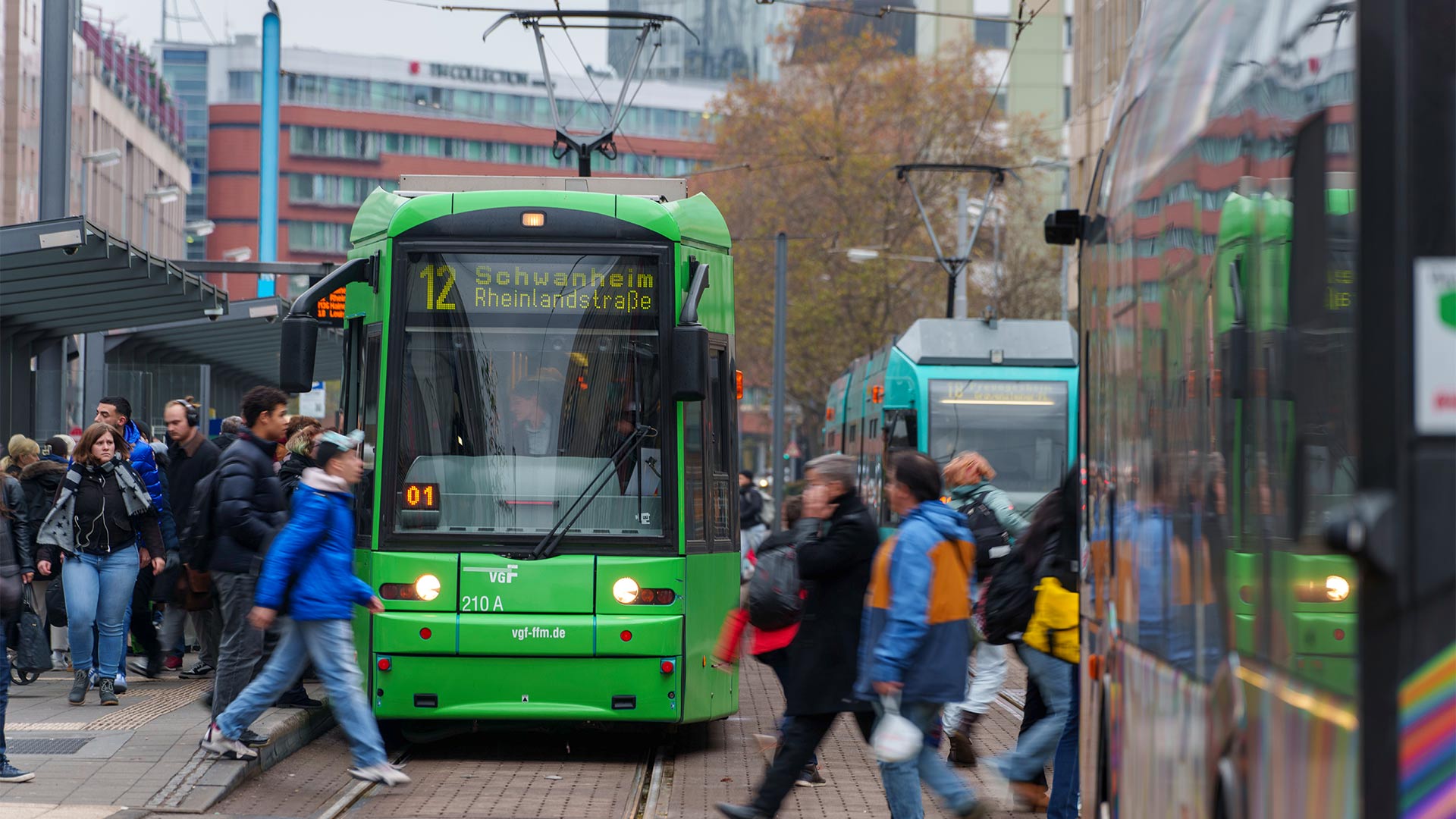Menschen gehen zwischen Bussen und Straßenbahnen an der Haltestelle Konstablerwache, Frankfurt am Main.