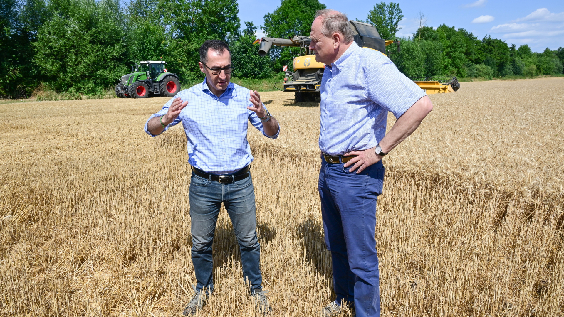 Bundesagrarminister Cem Özdemir (l, Bündnis 90/Die Grünen) unterhält sich mit Joachim Rukwied, dem Präsidenten des Deutschen Bauernverbands, auf einem Getreidefeld. | dpa