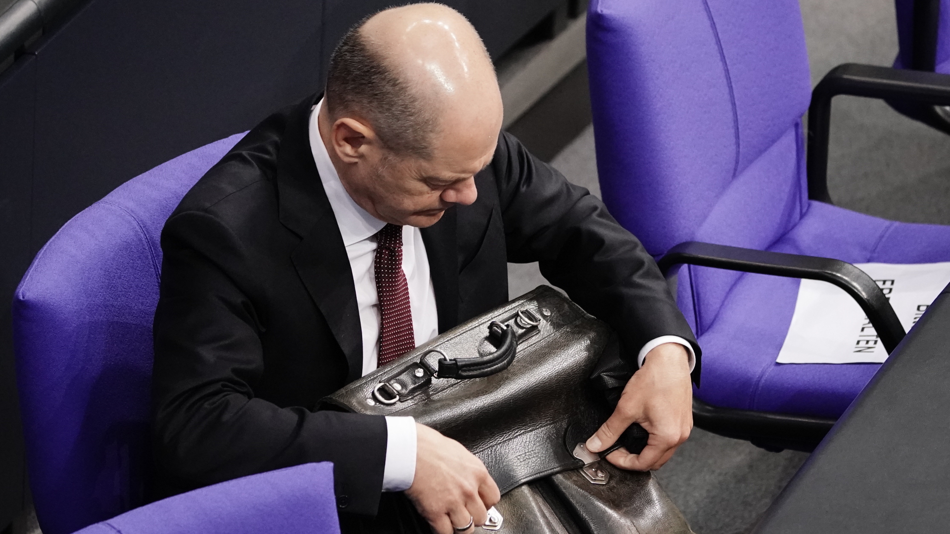 Olaf Scholz packt seine Tasche im Bundestag. | dpa
