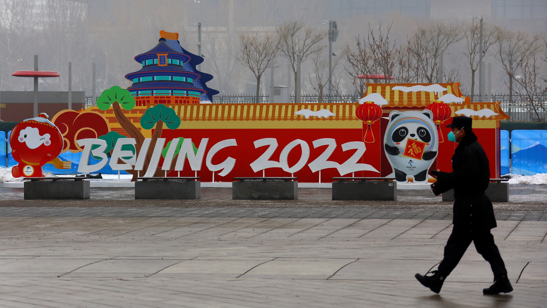 Ein Mann läuft an einer Werbetafel für die Olympischen Winterspiele in Peking vorbei. | REUTERS