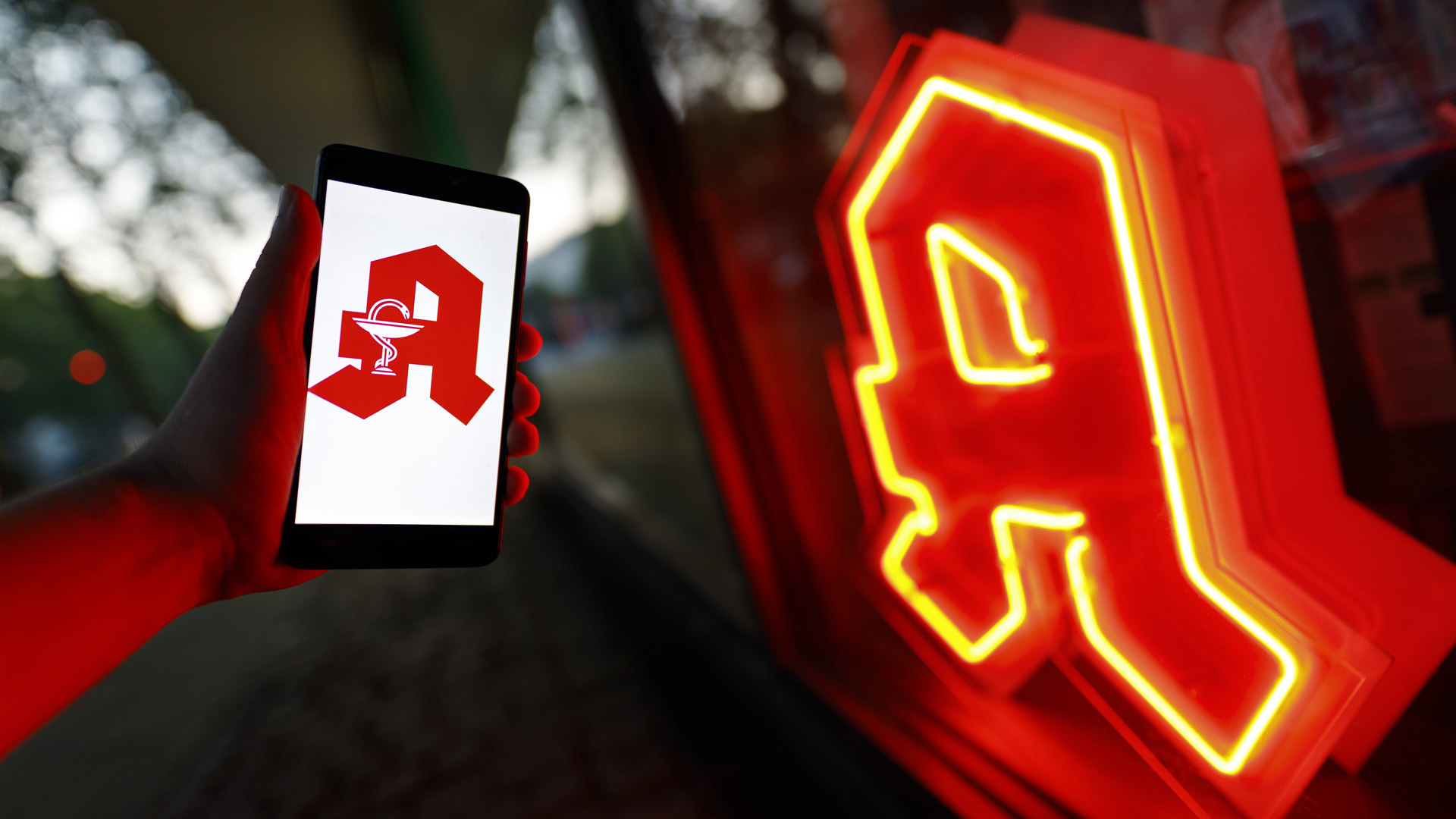 Leuchtendes Apotheken-Logo und rotes Apotheken-A auf einem Smartphone