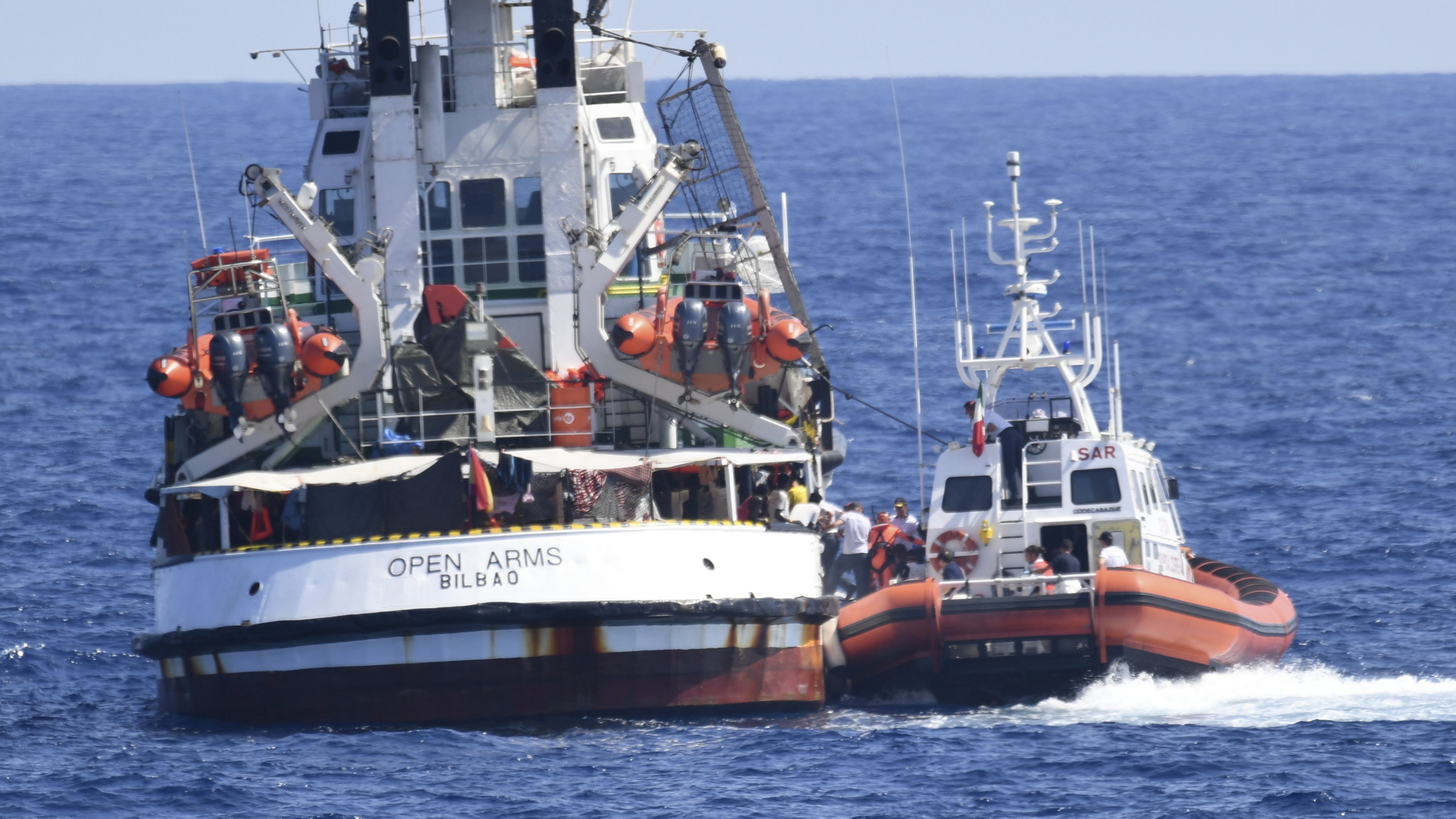Ein Schiff der italienischen Küstenwache (re.) liegt längsseits der "Open Arms". | AP
