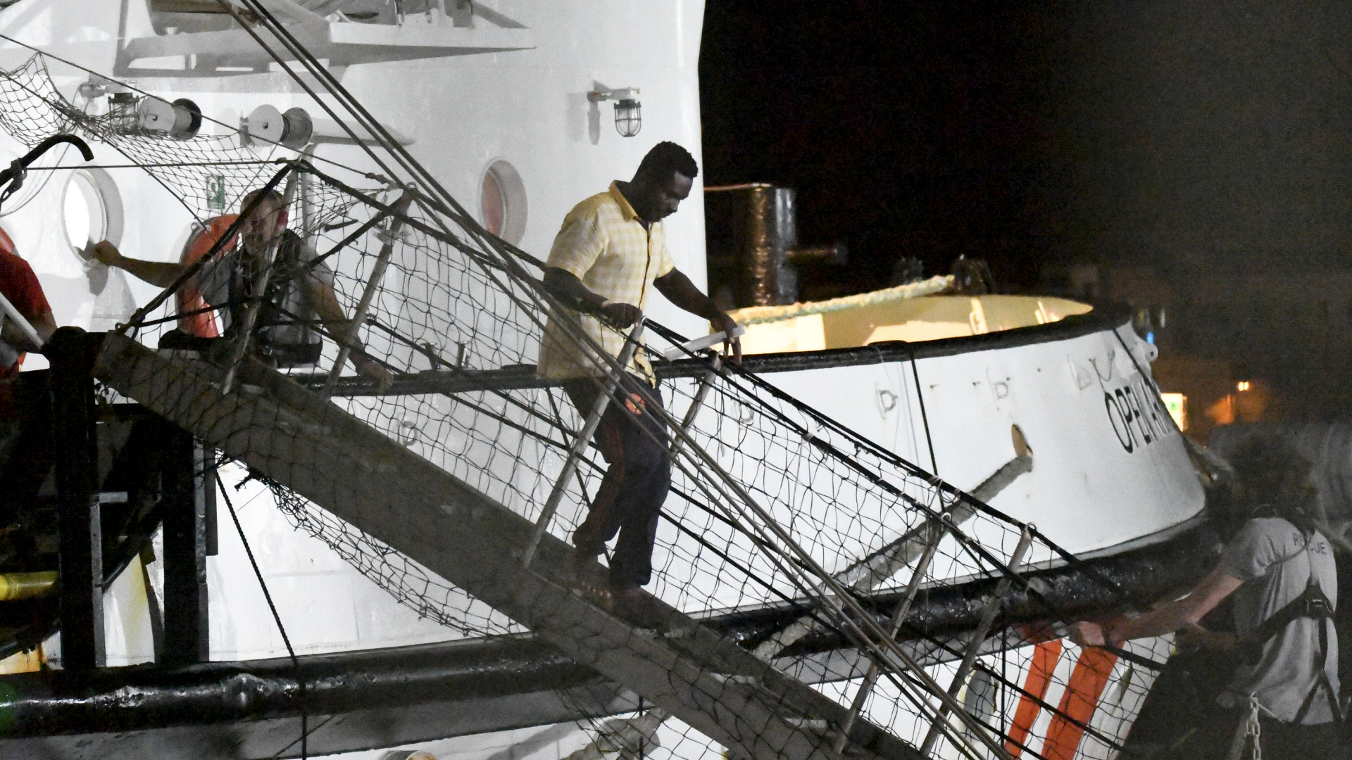 Ein Flüchtling verlässt das Rettungsschiff "Open Arms" und geht in Lampedusa an Land. | AP