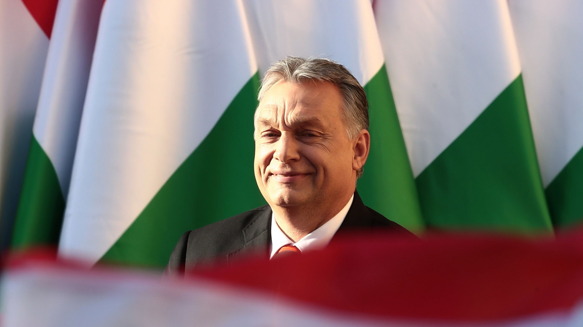 Ungarns Ministerpräsident Viktor Orban ist auf dem Rathausplatz von Szekesfehervar umgeben von grün-rot-weißen Flaggen.