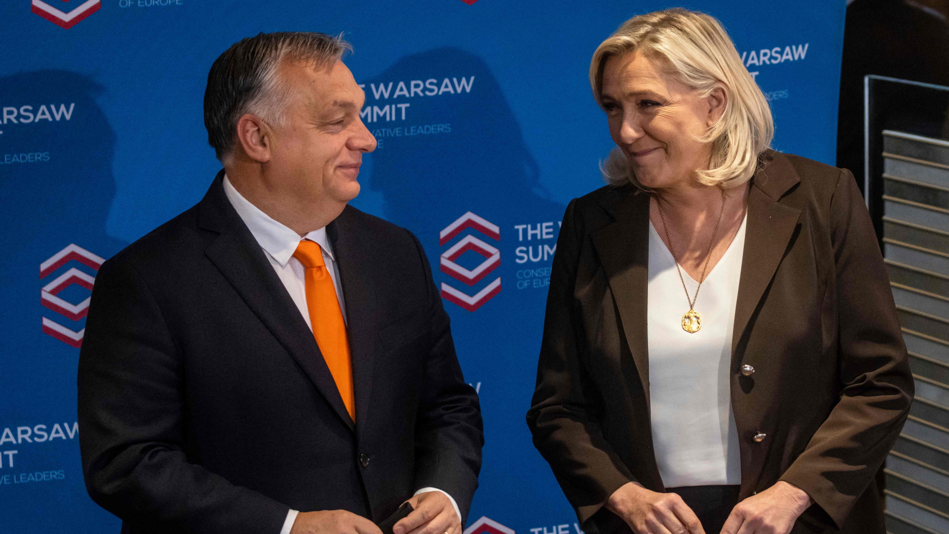 Ungarns Regierungschef Orban und Frankreichs Le Pen lächeln beim Warschauer Treffen der Rechtskonservativen an. | AFP