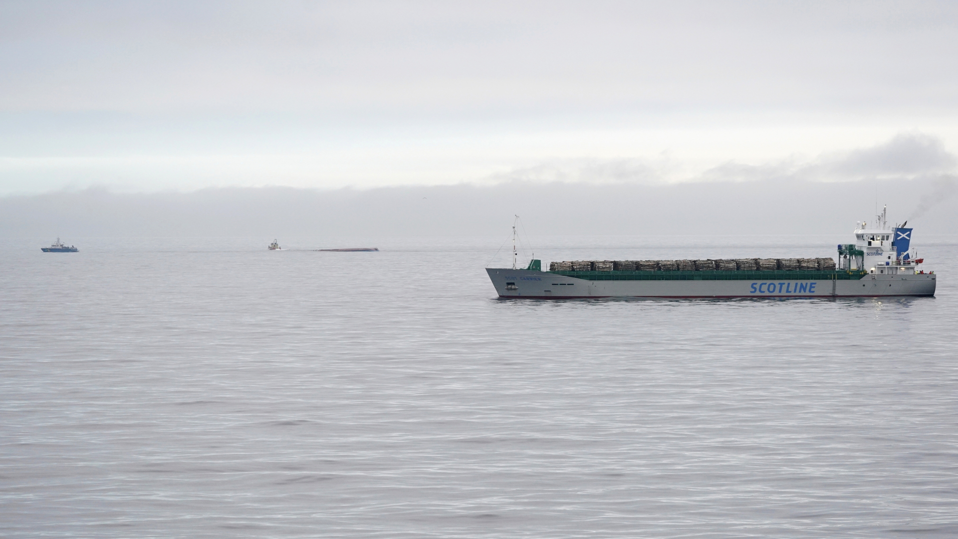 Das britische Frachtschiff in der Ostsee zwischen Ystad und der Insel Bornholm, im Hintergrund ist der mit dem Kiel nach oben liegende Frachter zu sehen.