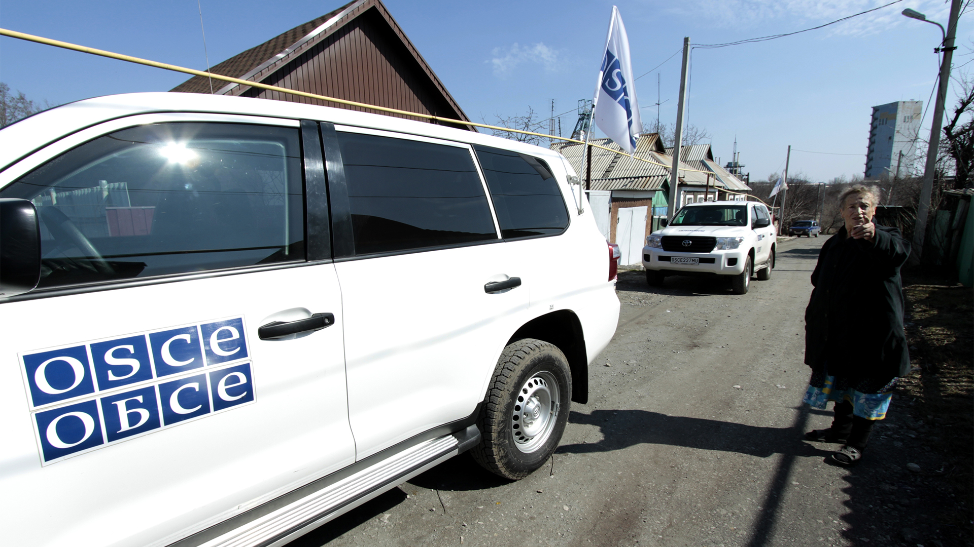 Fahrzeuge der OSZE fahren durch einen Ort bei Donezk