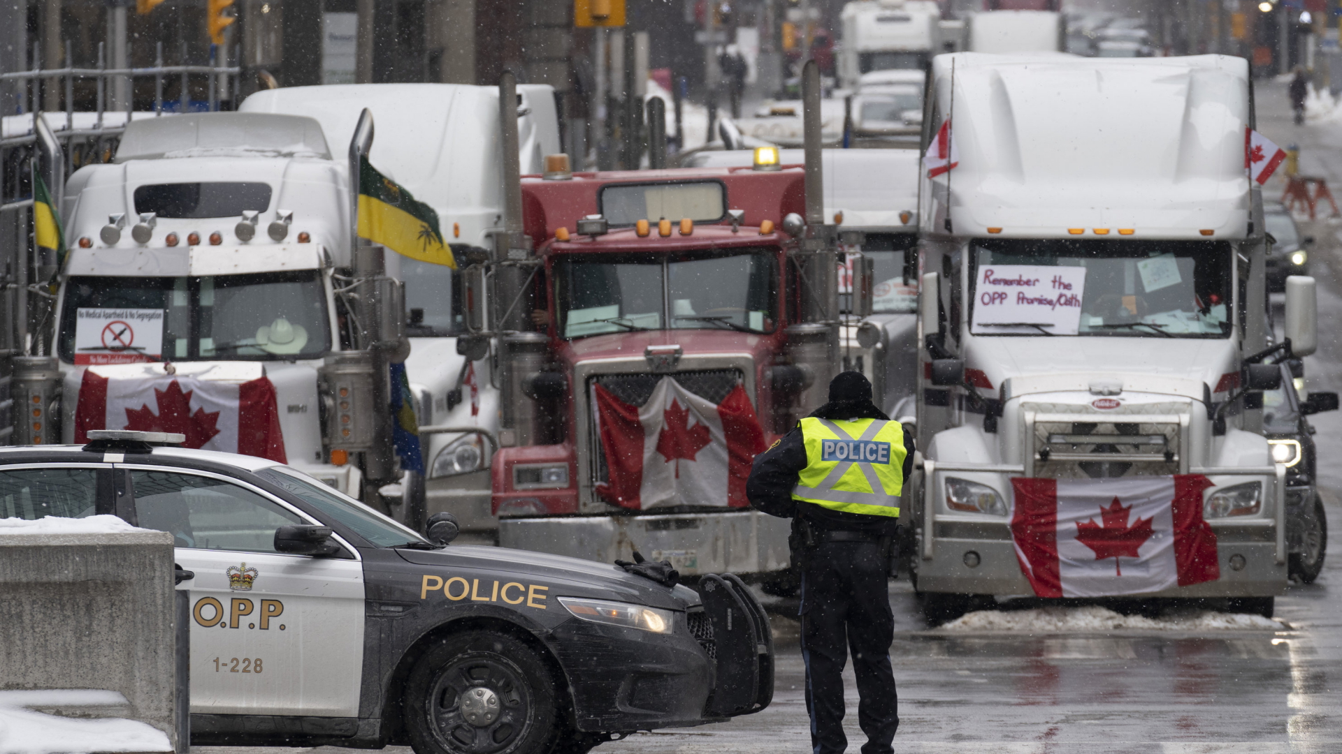 Ein Polizist schaut in Ottawa (Kanada) auf Lkw, die die Stadt blockieren, um gegen Corona-Maßnahmen zu protestieren | AP