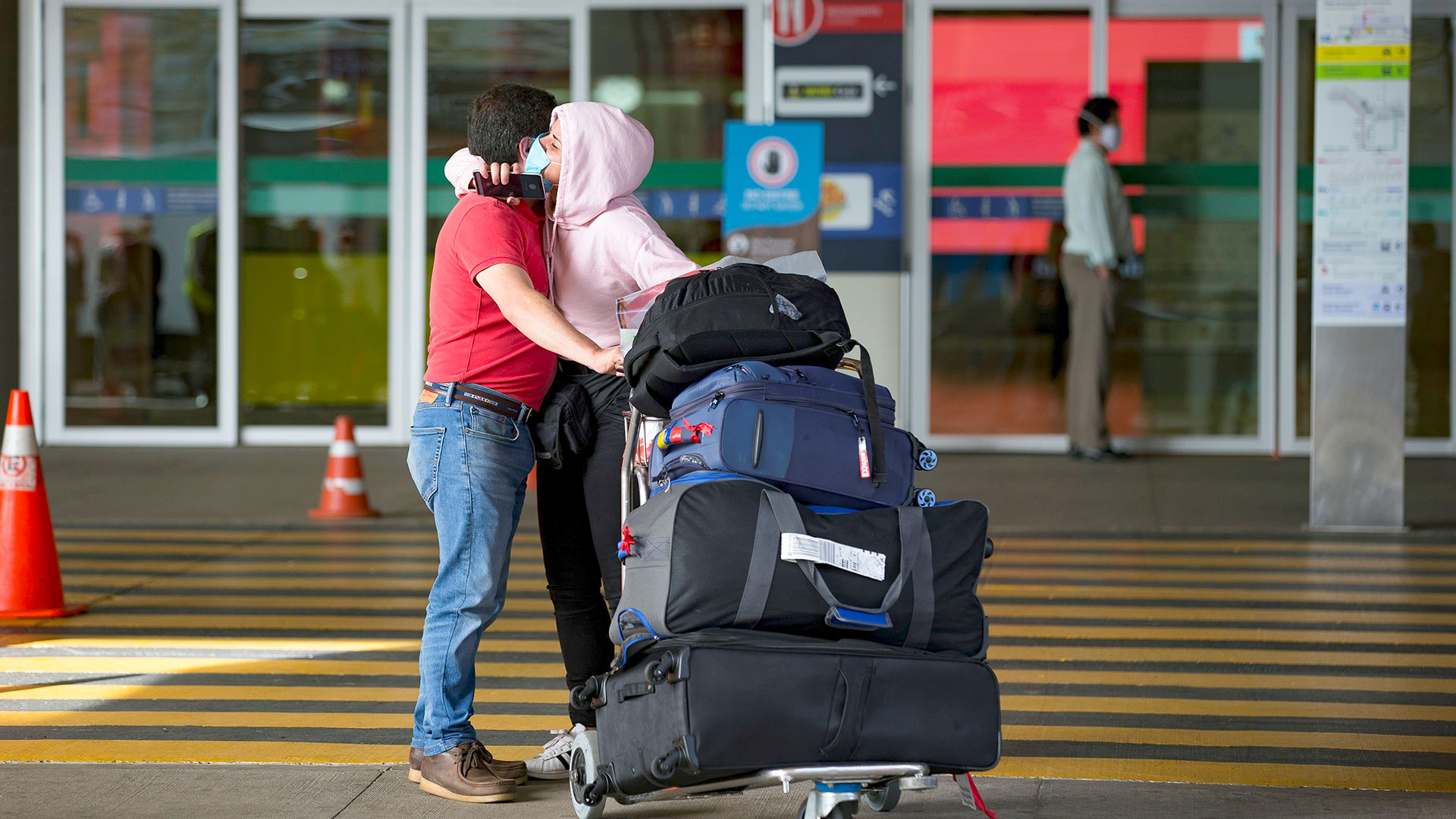 Ein Paar umarmt sich am Flughafen während der Corona-Pandemie.
