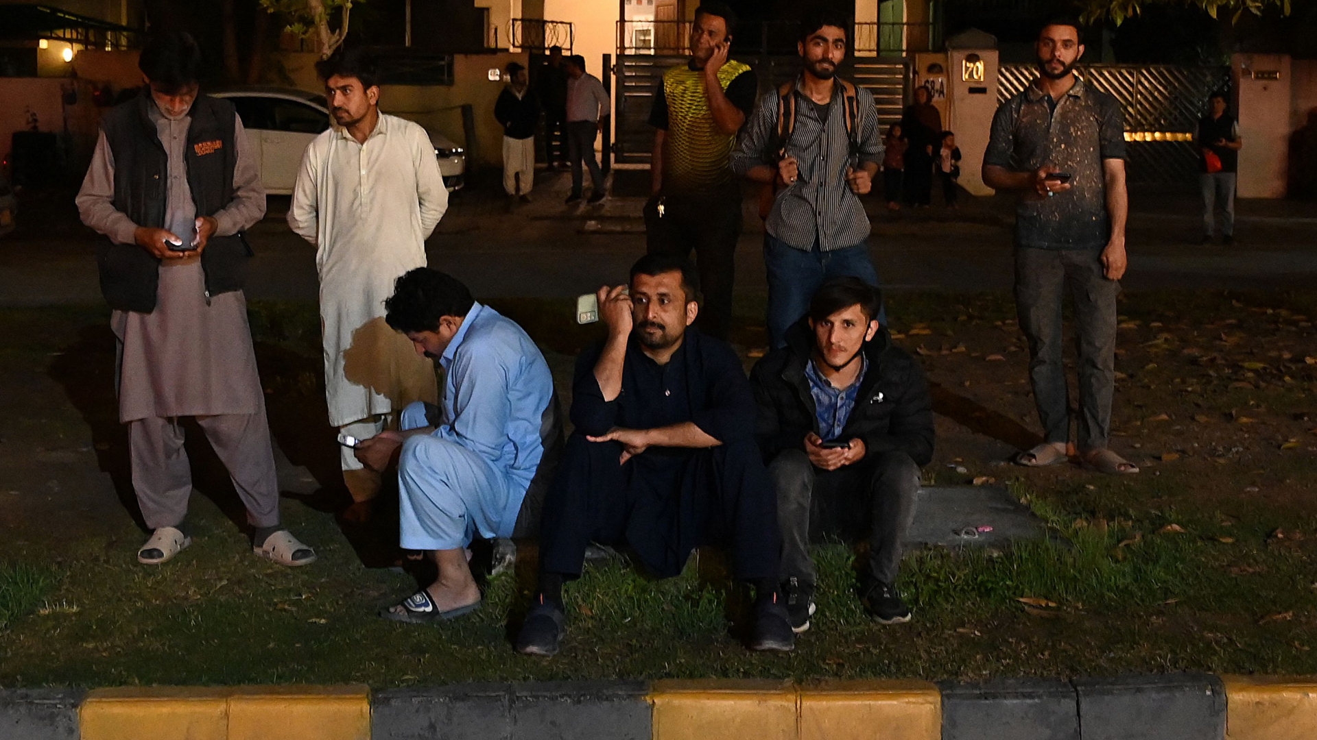 Einwohner stehen nach einem Erdbeben in Islamabad vor einem Gebäude auf der Straße