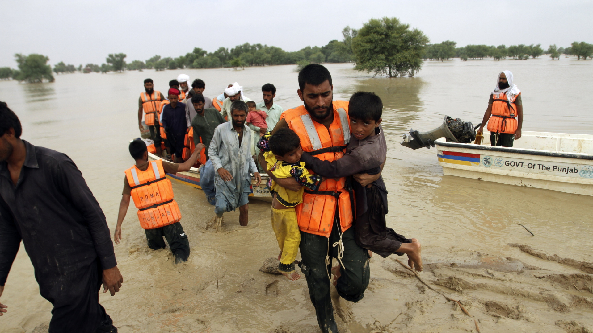 Armeeangehörige evakuieren Menschen aus einem überschwemmten Gebiet im pakistanischen Rajanpur. | AP