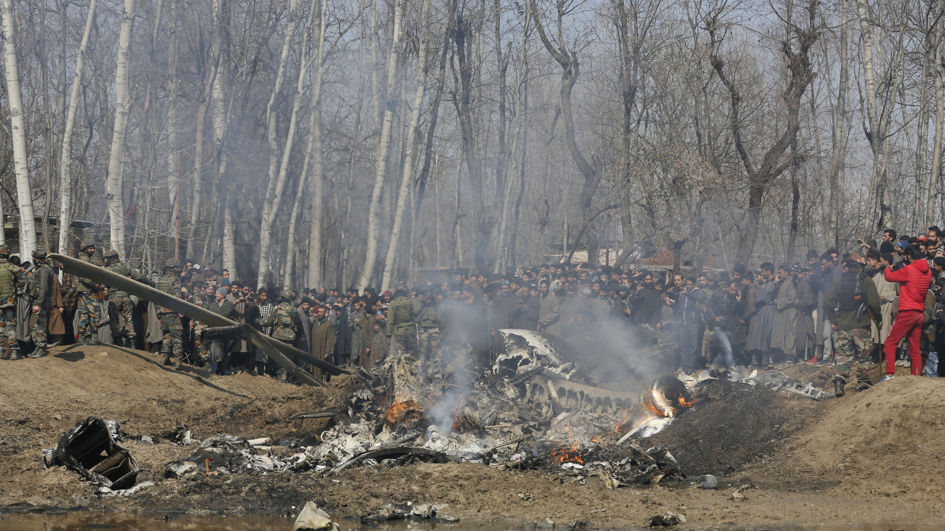 Anwohner stehen am Wrack eines abgestürzten indischen Flugzeugs - vermutlich ein Helikopter.
