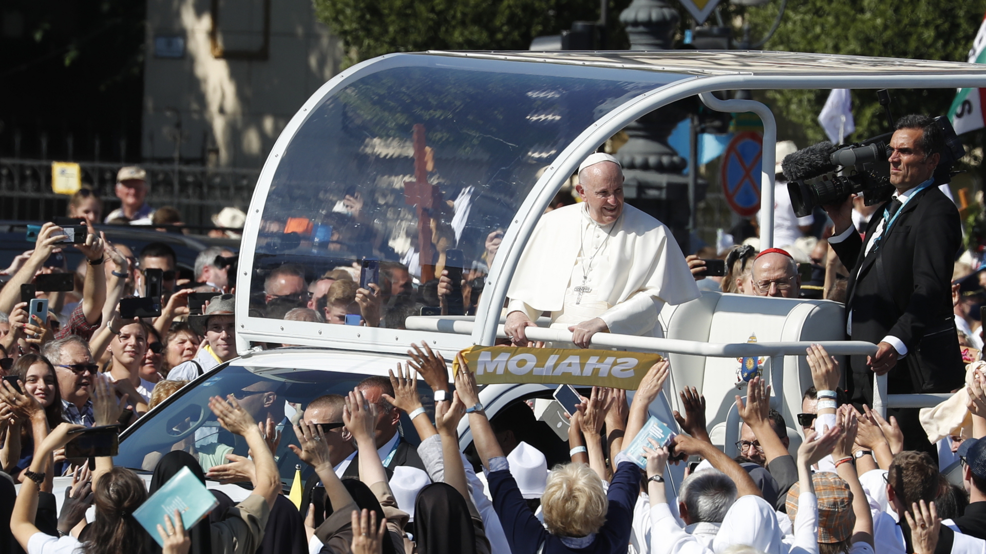 Papst Franziskus fährt im Papamobil vorbei an jubelnden Menschen in Budapest. | dpa