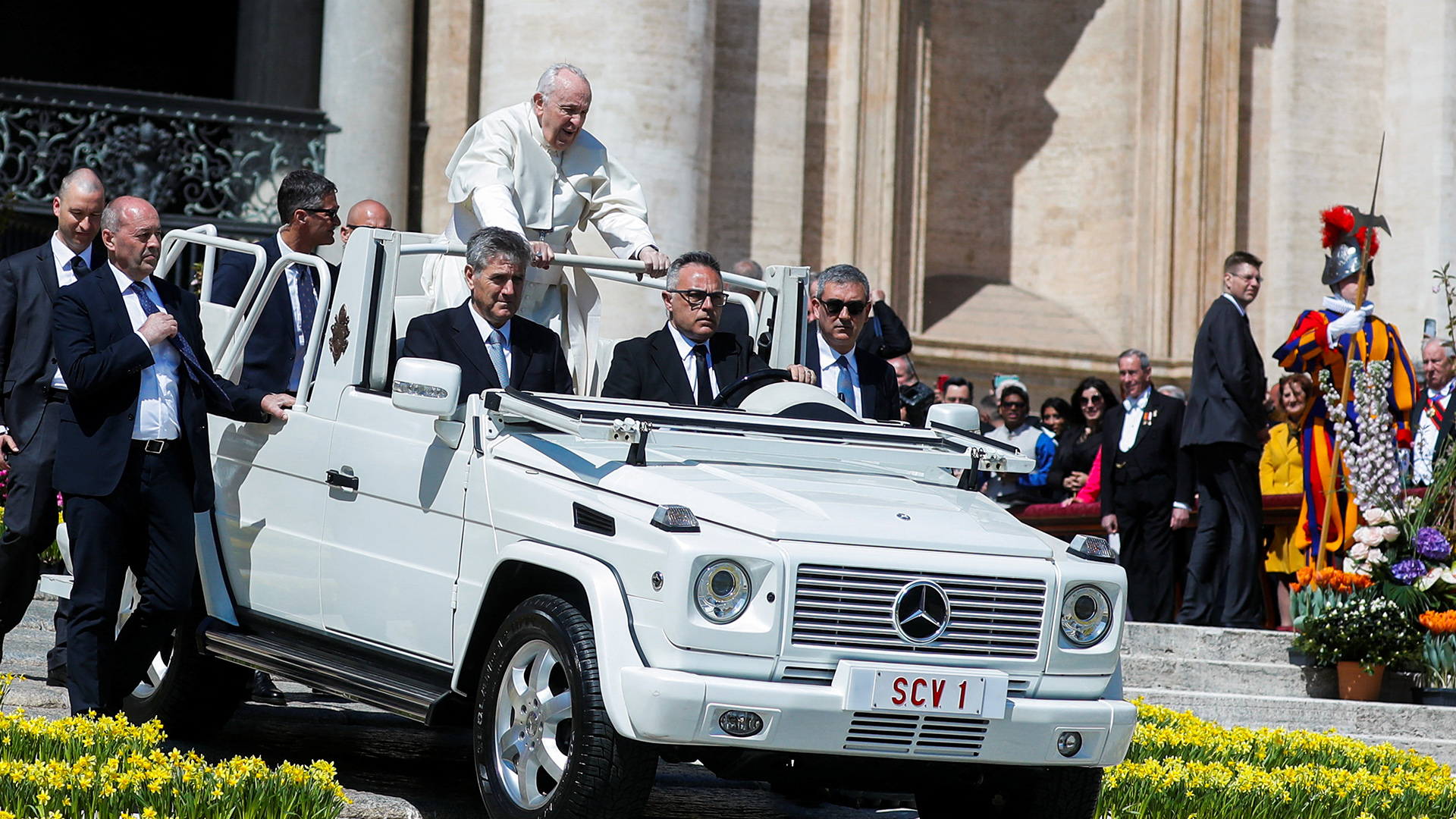 Papst Franziskus fährt stehend in seinem Papamobil. | REUTERS