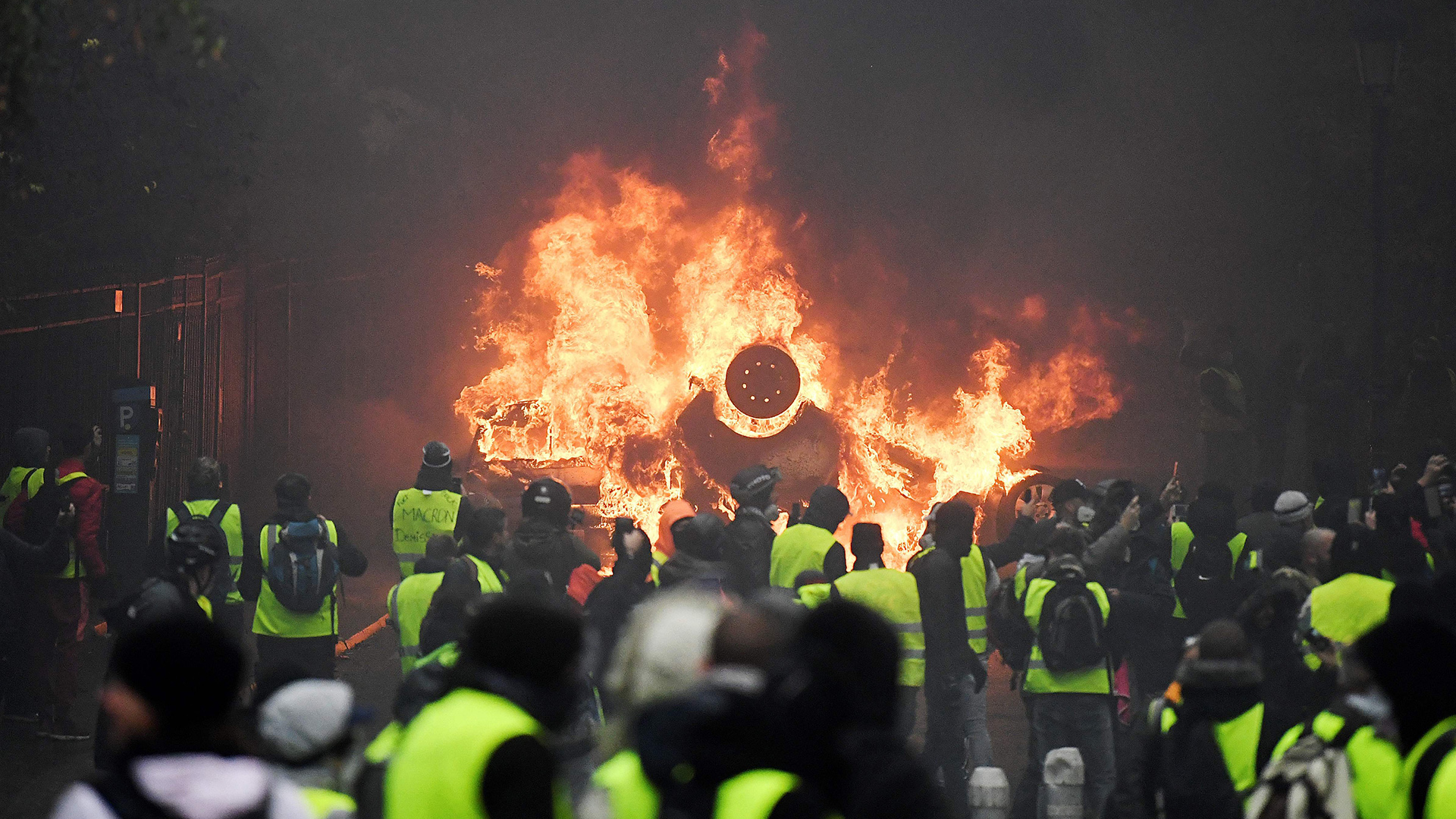 Demonstranten vor brennendem Auto | Bildquelle: AFP