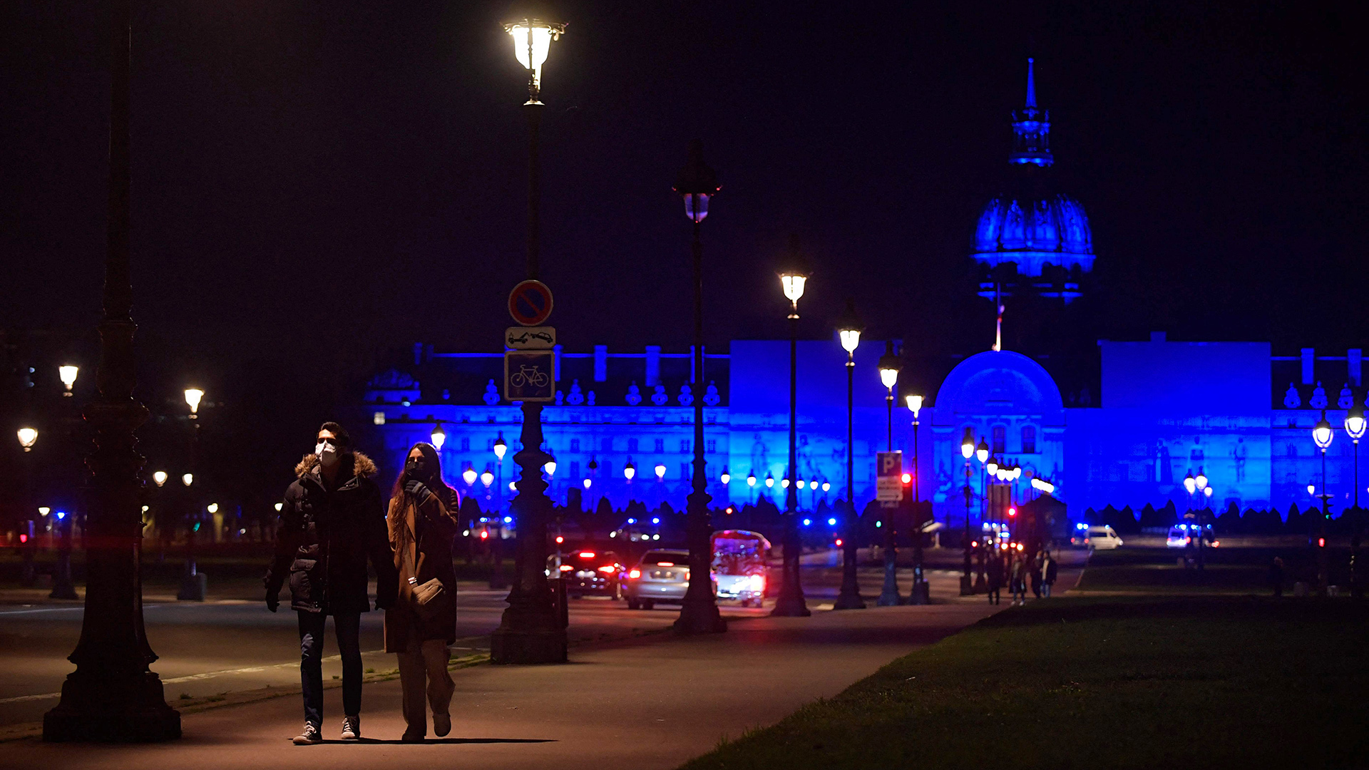  Ein Paar geht vor dem "Hotel des Invalides" spazieren, das anlässlich der französischen EU-Ratspräsidentschaft in blauem Licht erstrahlt, Paris. | AFP