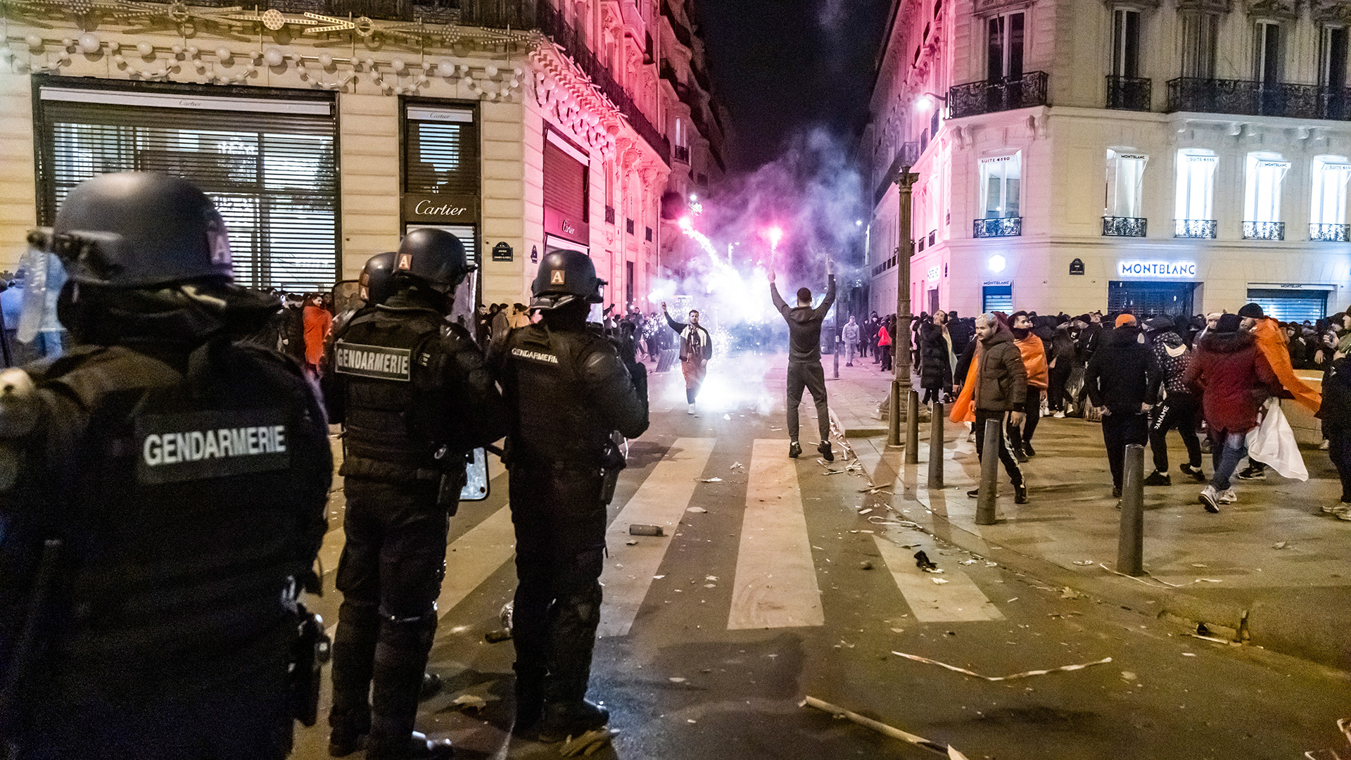 Polizisten stehen Wache, während französische und marokkanische Fans den Sieg ihrer Mannschaften im Viertelfinale der FIFA-WM auf der Pariser Champs Élysées feiern. | EPA
