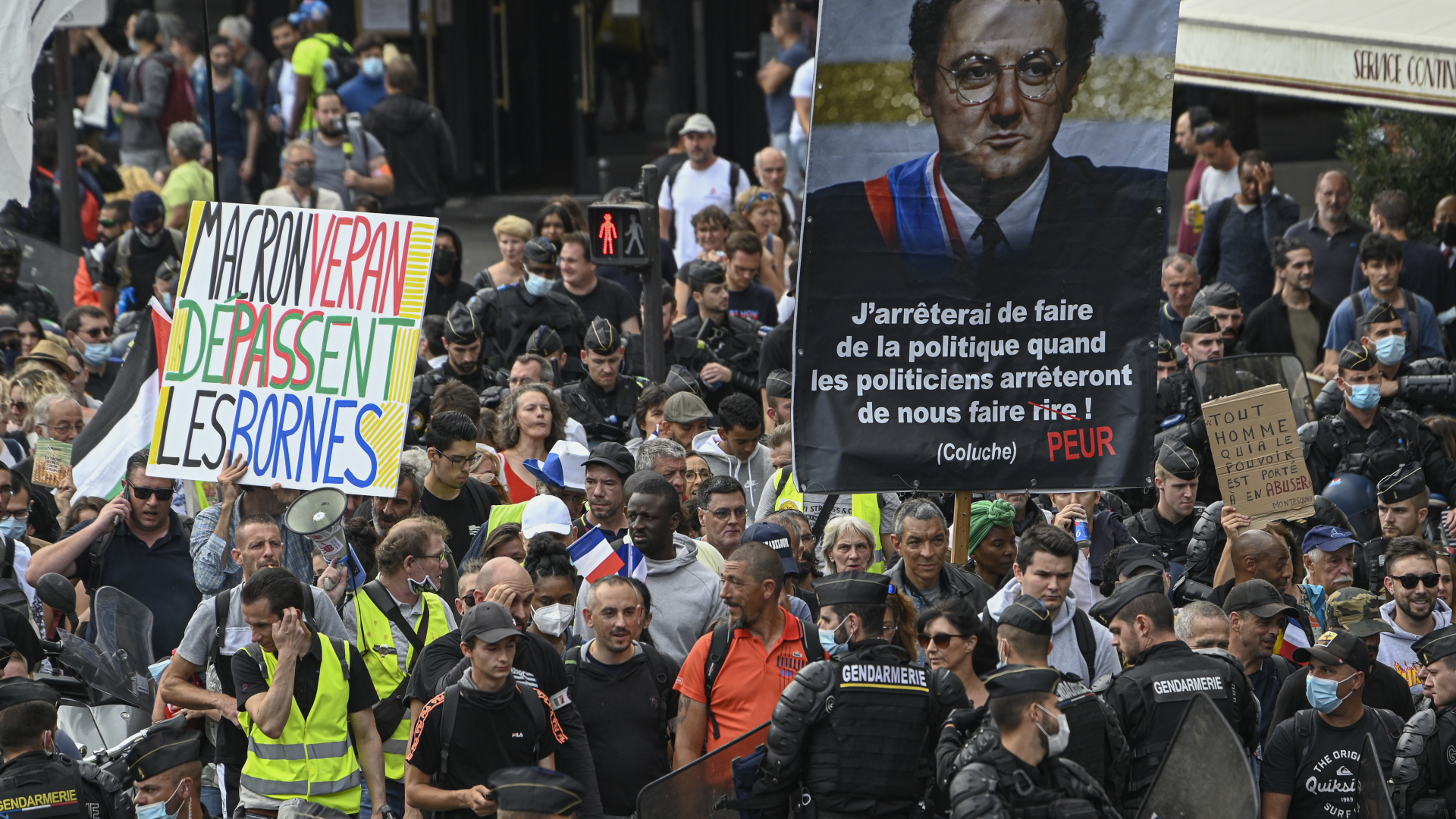 Demonstranten gehen in Paris bei einem Protest gegen die verschärften Corona-Regeln der französischen Regierung auf einer Straße. | dpa