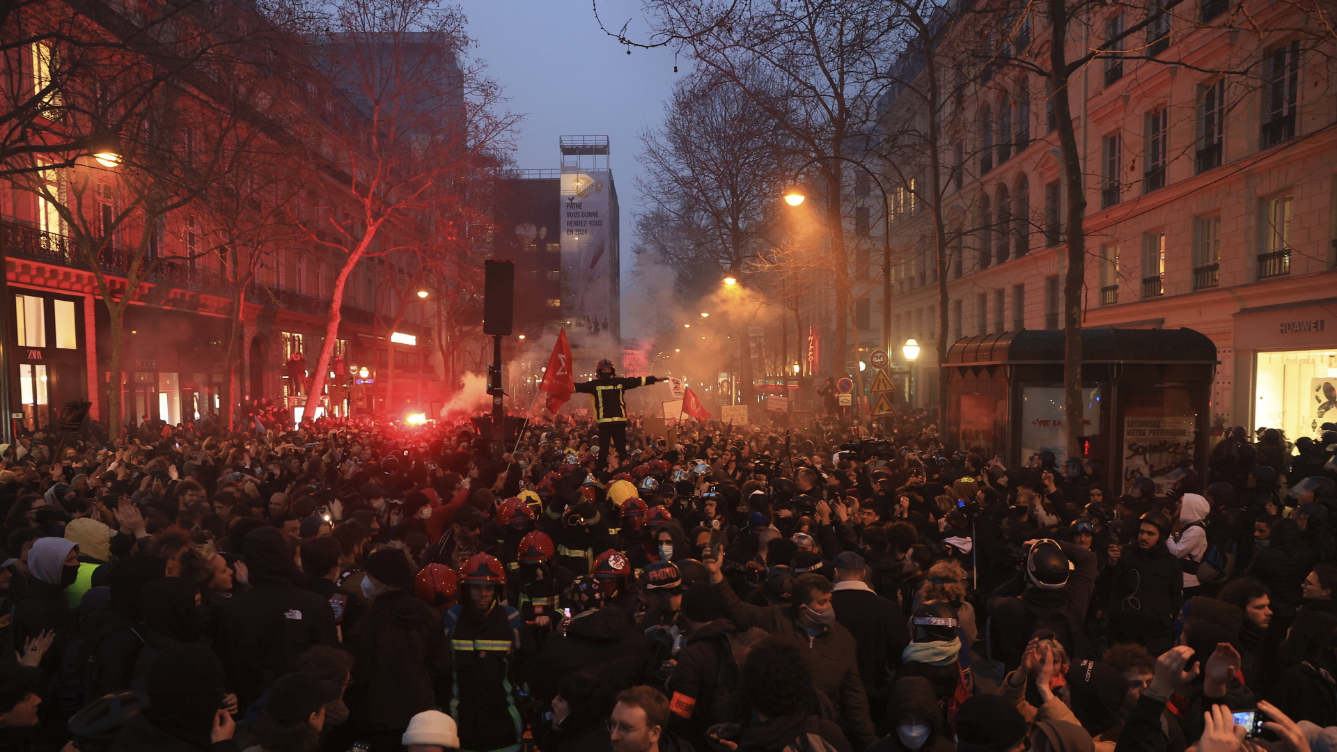 Eine Pariser Straße voller Demonstranten in der Abenddämmerung.