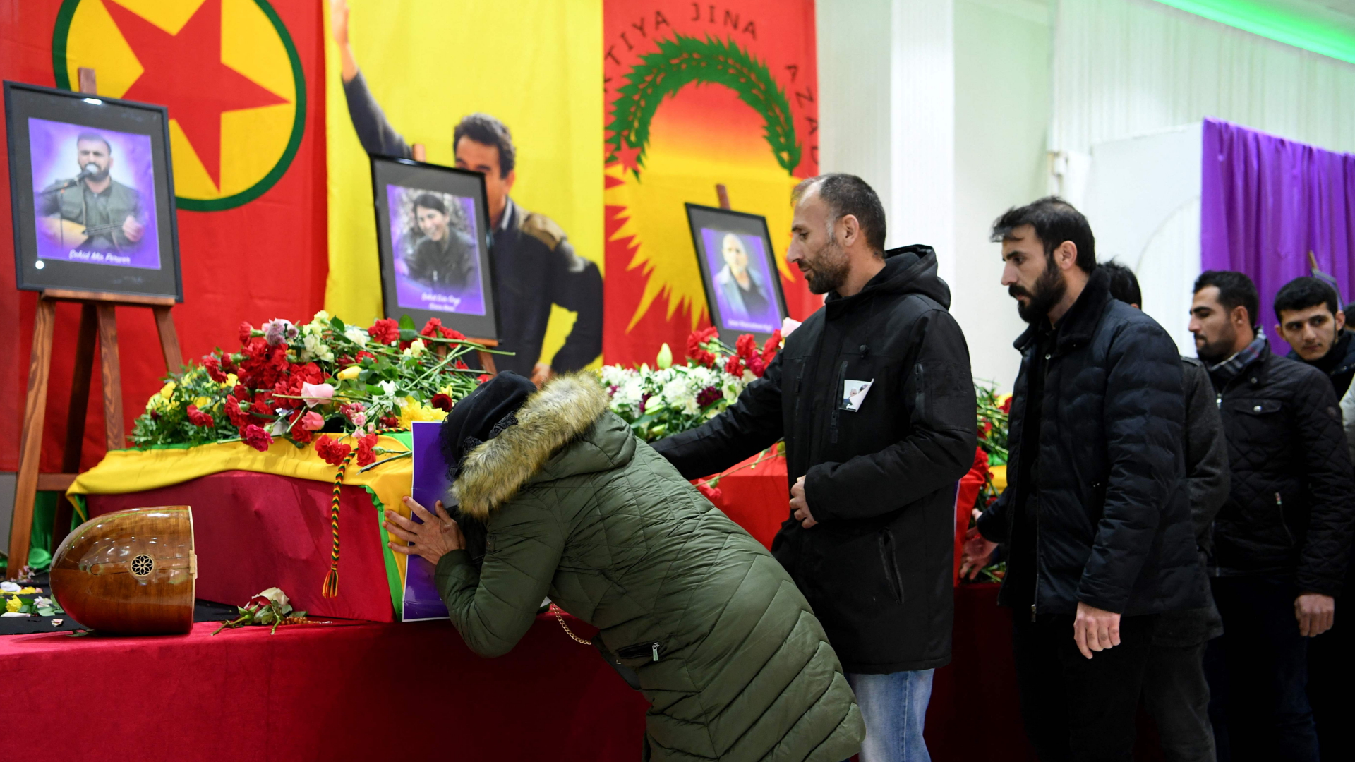Mitglieder der kurdischen Gemeinschaft  stehen vor den Särgen der drei Opfer und nehmen Abschied. | AFP