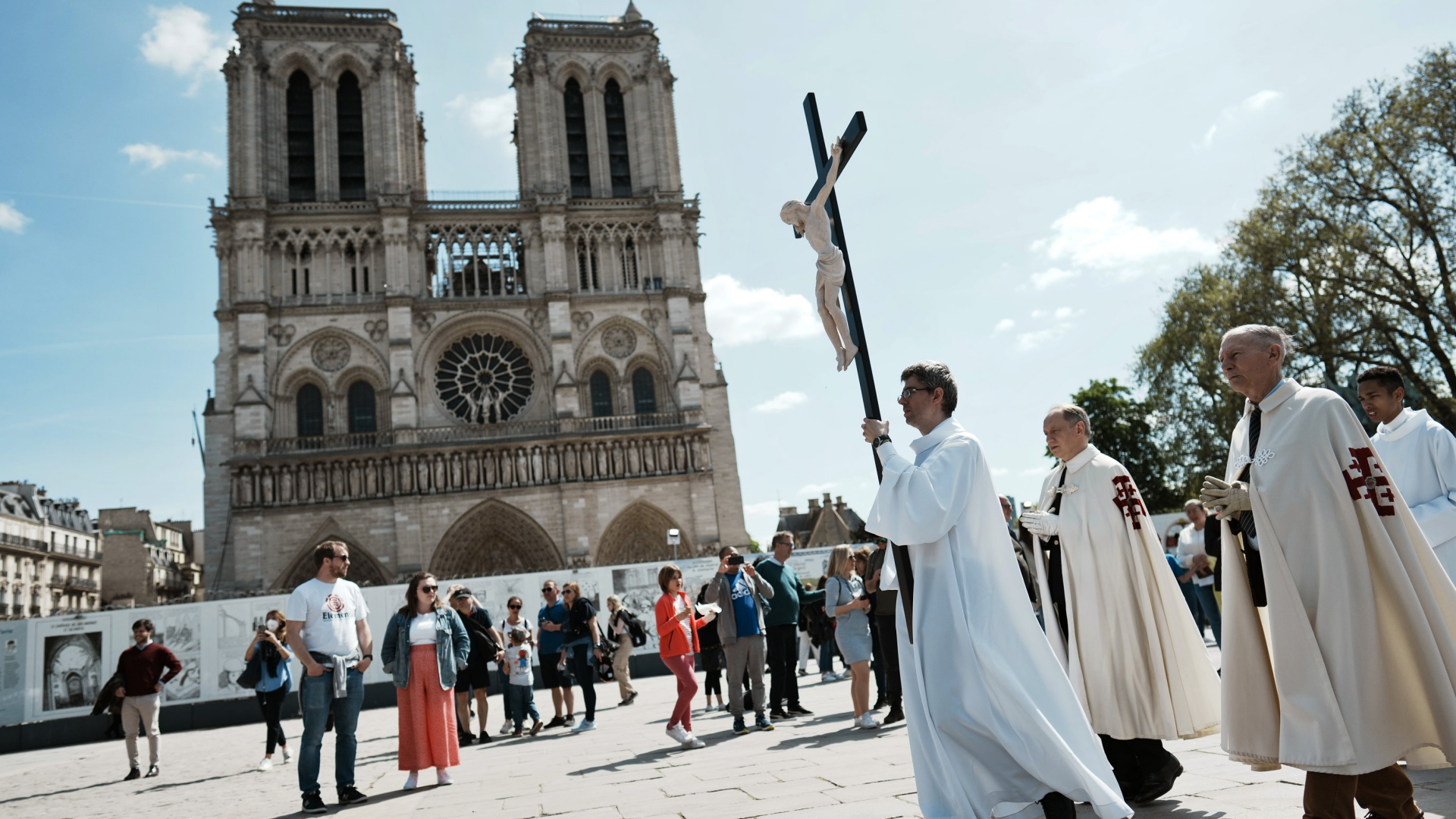 Mitglieder der katholischen Kirche tragen am Karfreitag 2022 ein großes Kreuz über den Platz vor der Kathedrale Notre-Dame. | AP