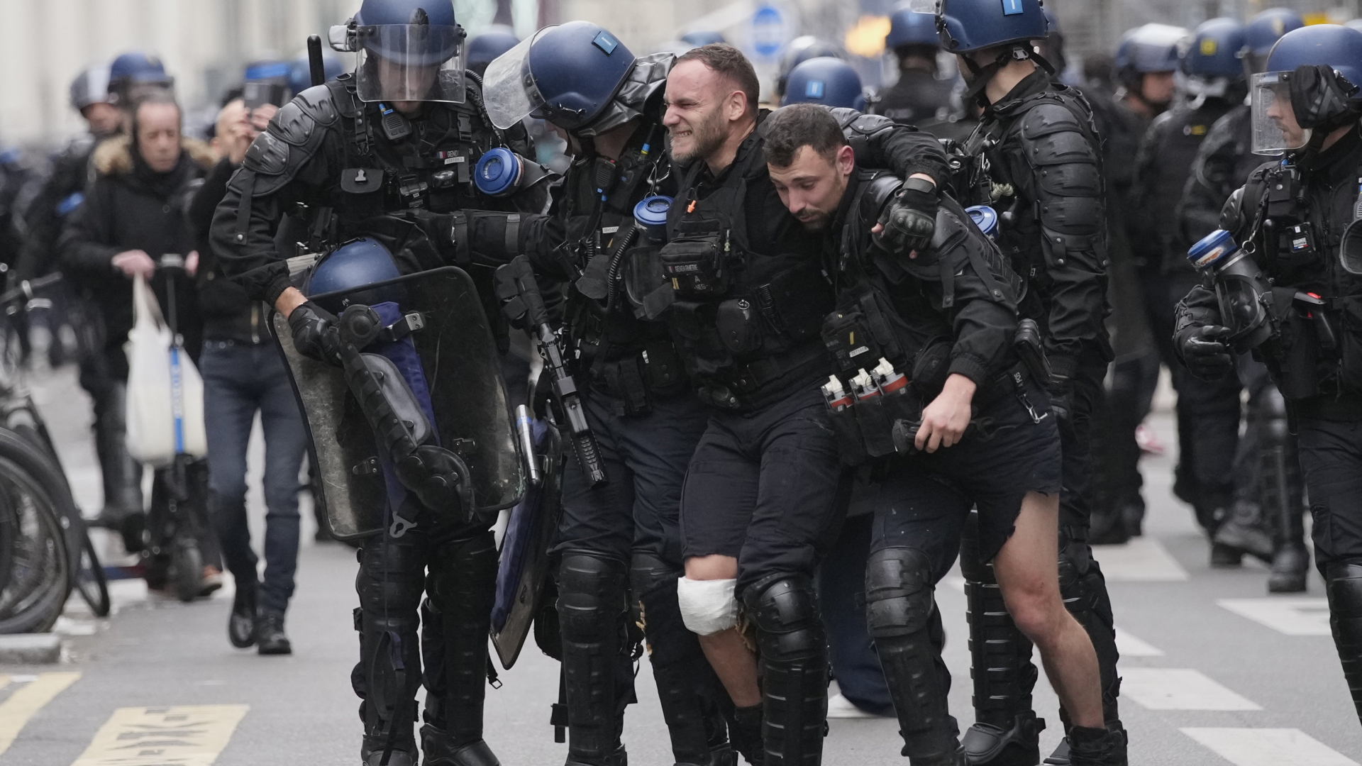 Ein verletzter Polizist wird in Paris von Kollegen gestützt.