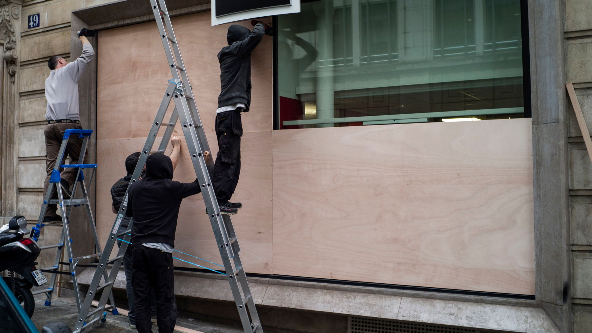 Männer schützen Fensterscheiben einer Bank in Paris mit Holzplatten | Bildquelle: YOAN VALAT/EPA-EFE/REX/Shutterst
