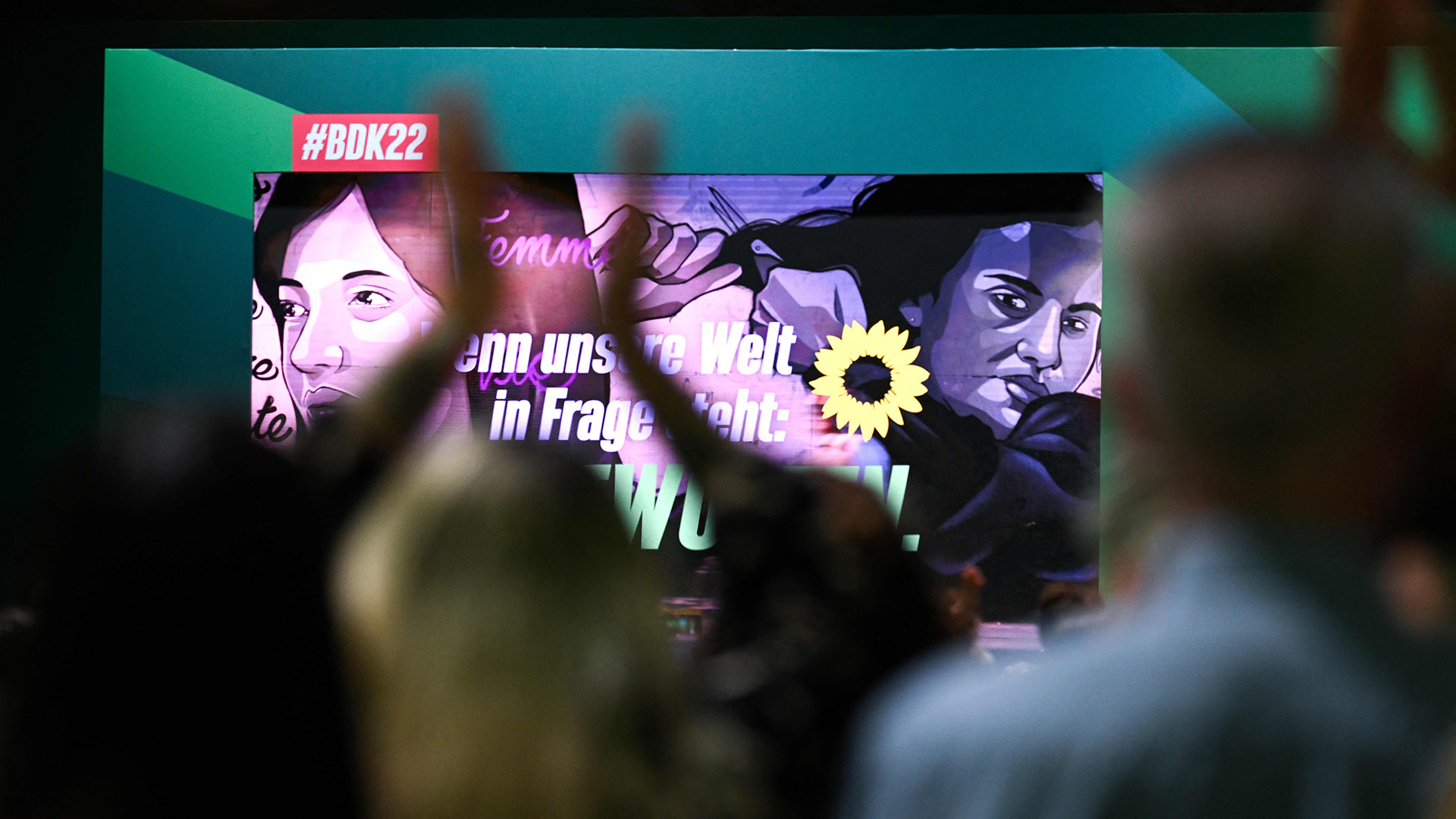 Jemand steht vor einem großen Bildschirm und hebt die Hände über den Kopf. | AFP