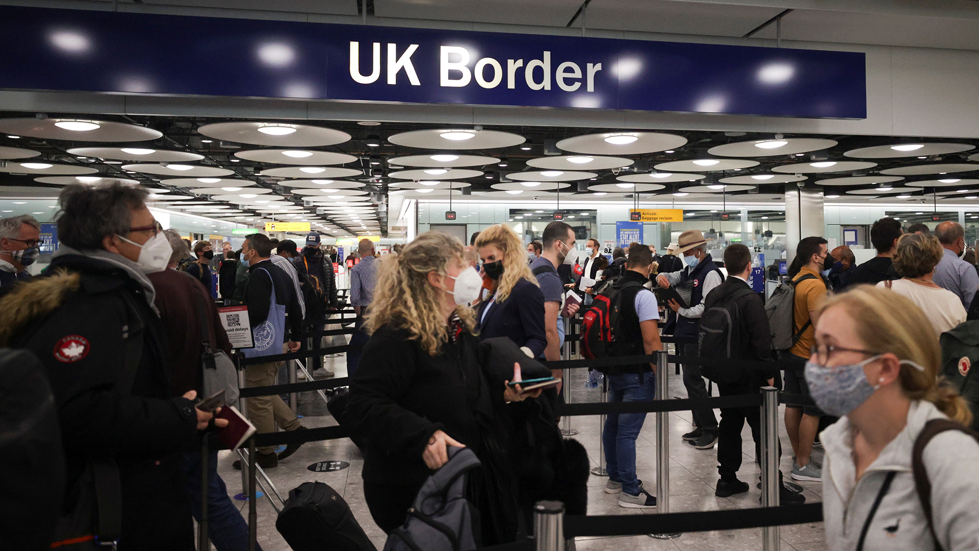 Ankommende Passagiere stehen bei der britischen Grenzkontrolle im Terminal 5 des Flughafens Heathrow in London. | REUTERS